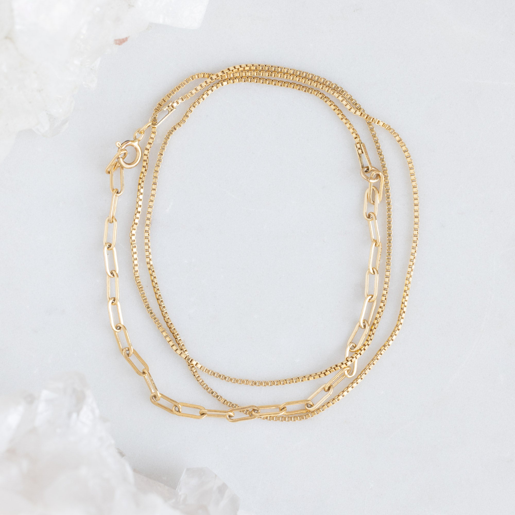 The 4-in-1 Cable Chain Bracelet in 14K Yellow Gold on White Marble Surface