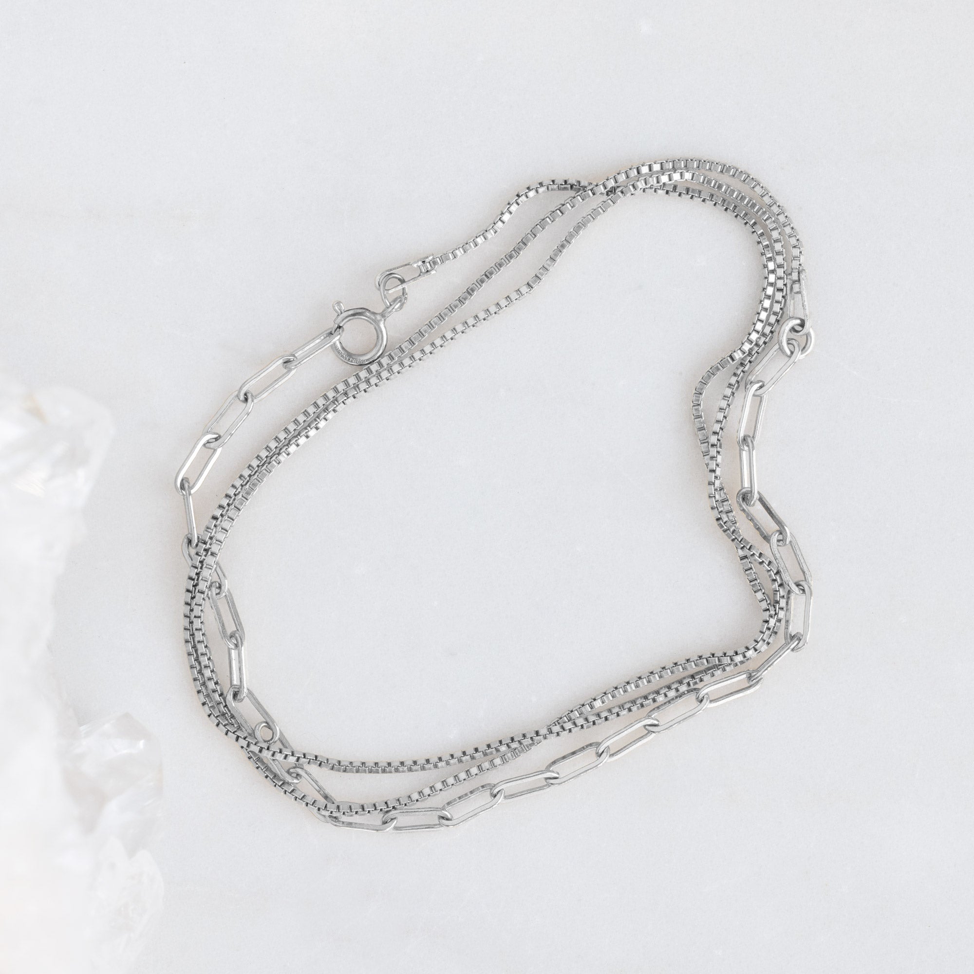The 4-in-1 Cable Chain Bracelet in 14K White Gold on White Marble Surface