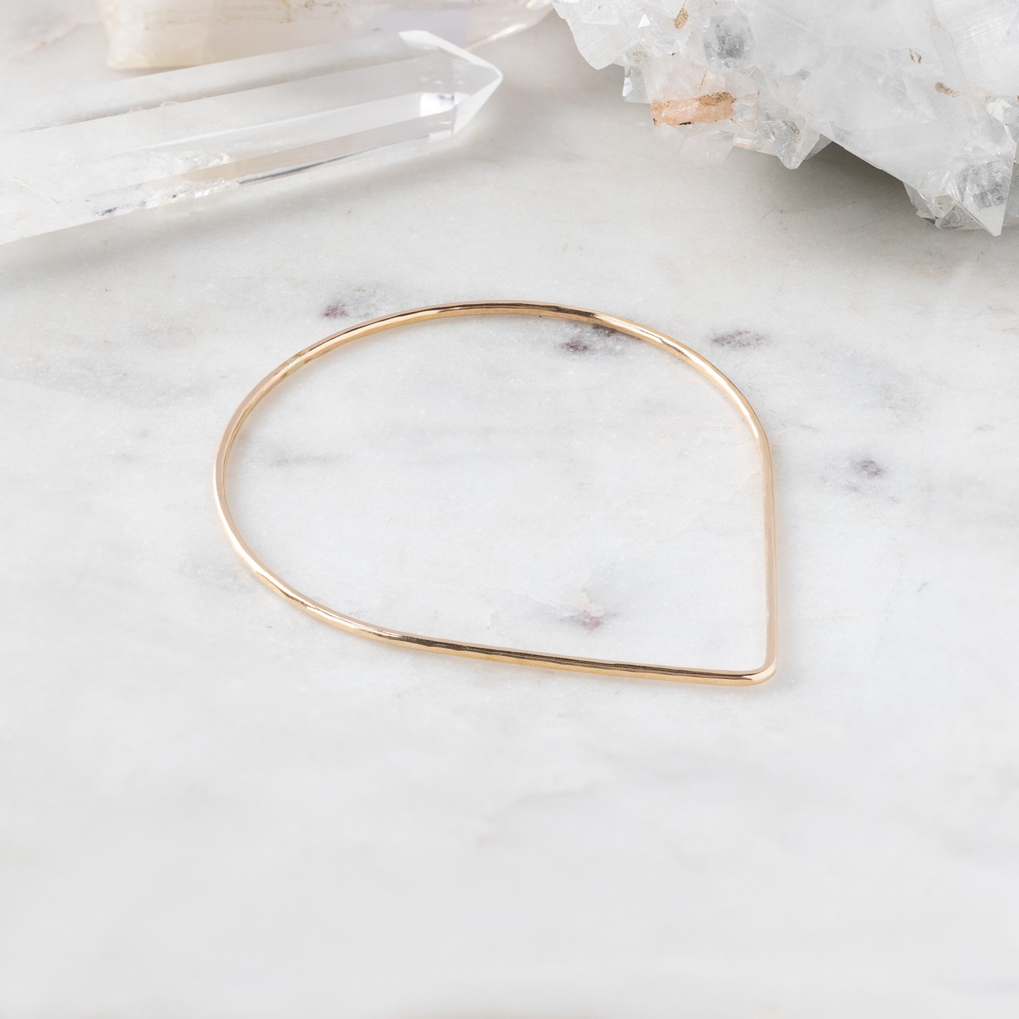 The Peak Stacking Bangle in Yellow Gold Filled on White Marble