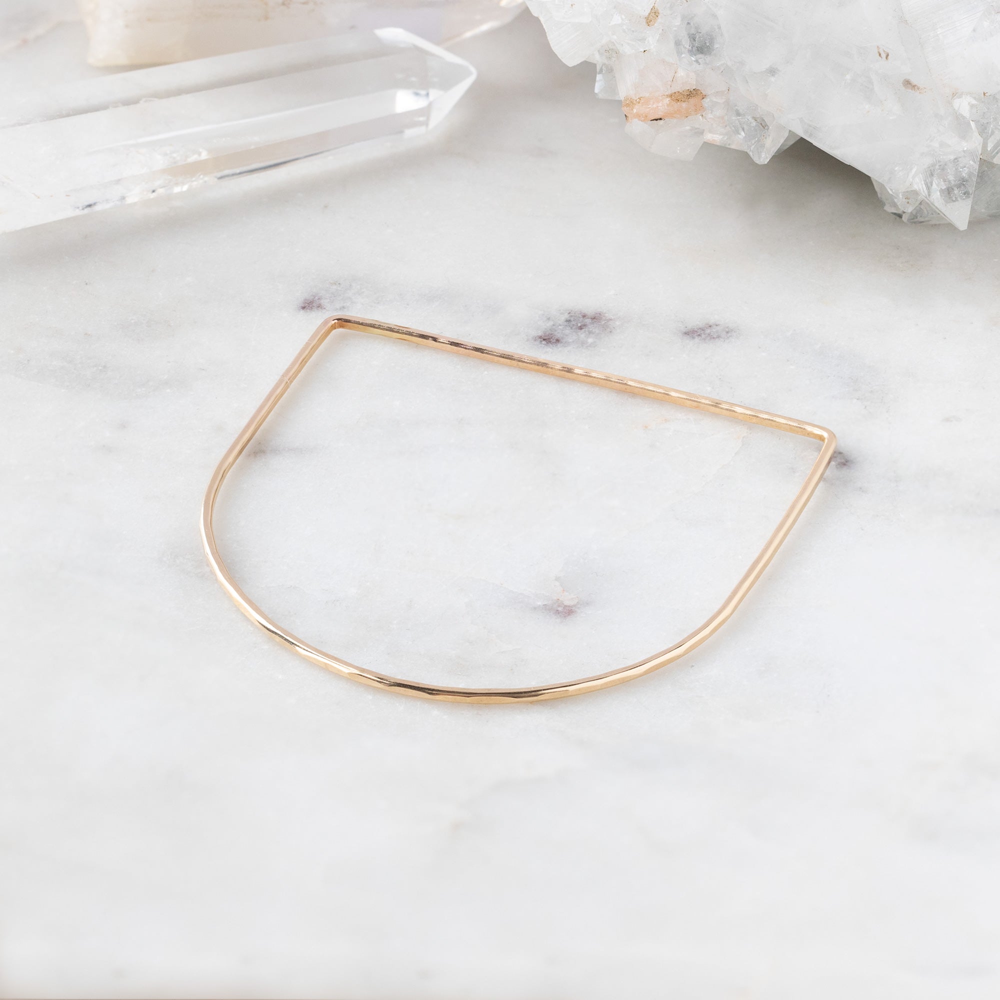 The Lune Stacking Bangle in Yellow Gold Filled on White Marble