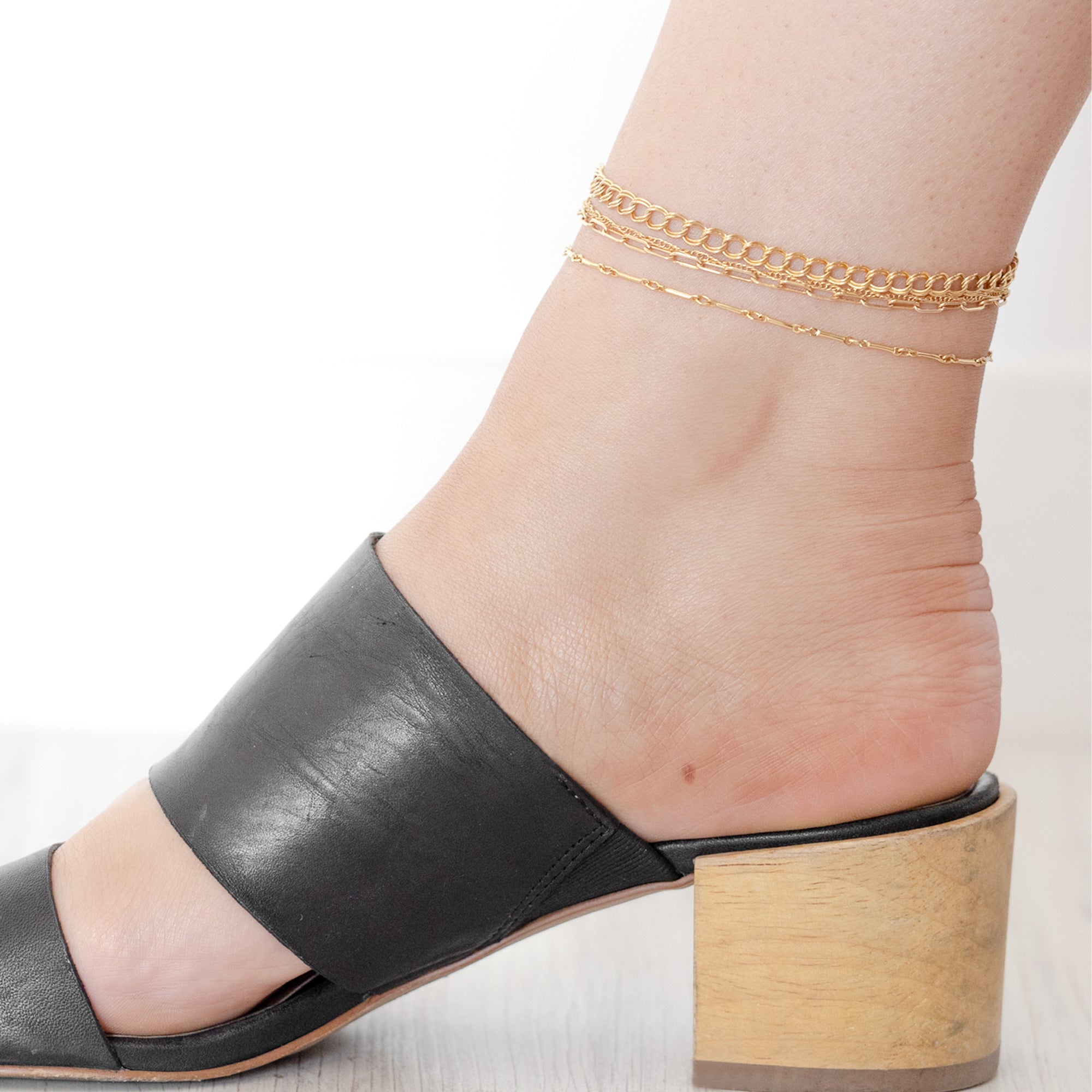 The Bold Curb Chain Anklet in Yellow Gold Filled Stacked on Model