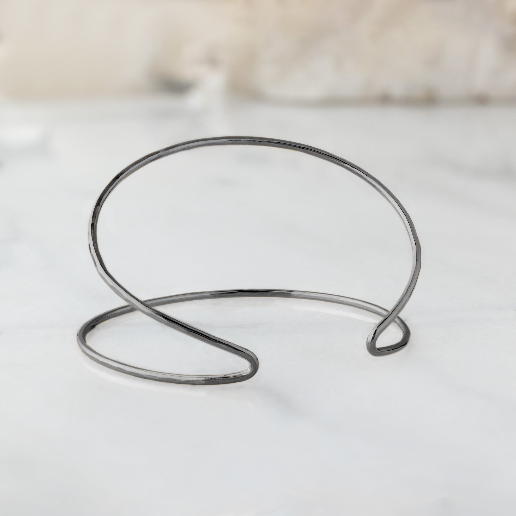 The Arrow Cuff Bracelet in Oxidized Sterling Silver on White Marble