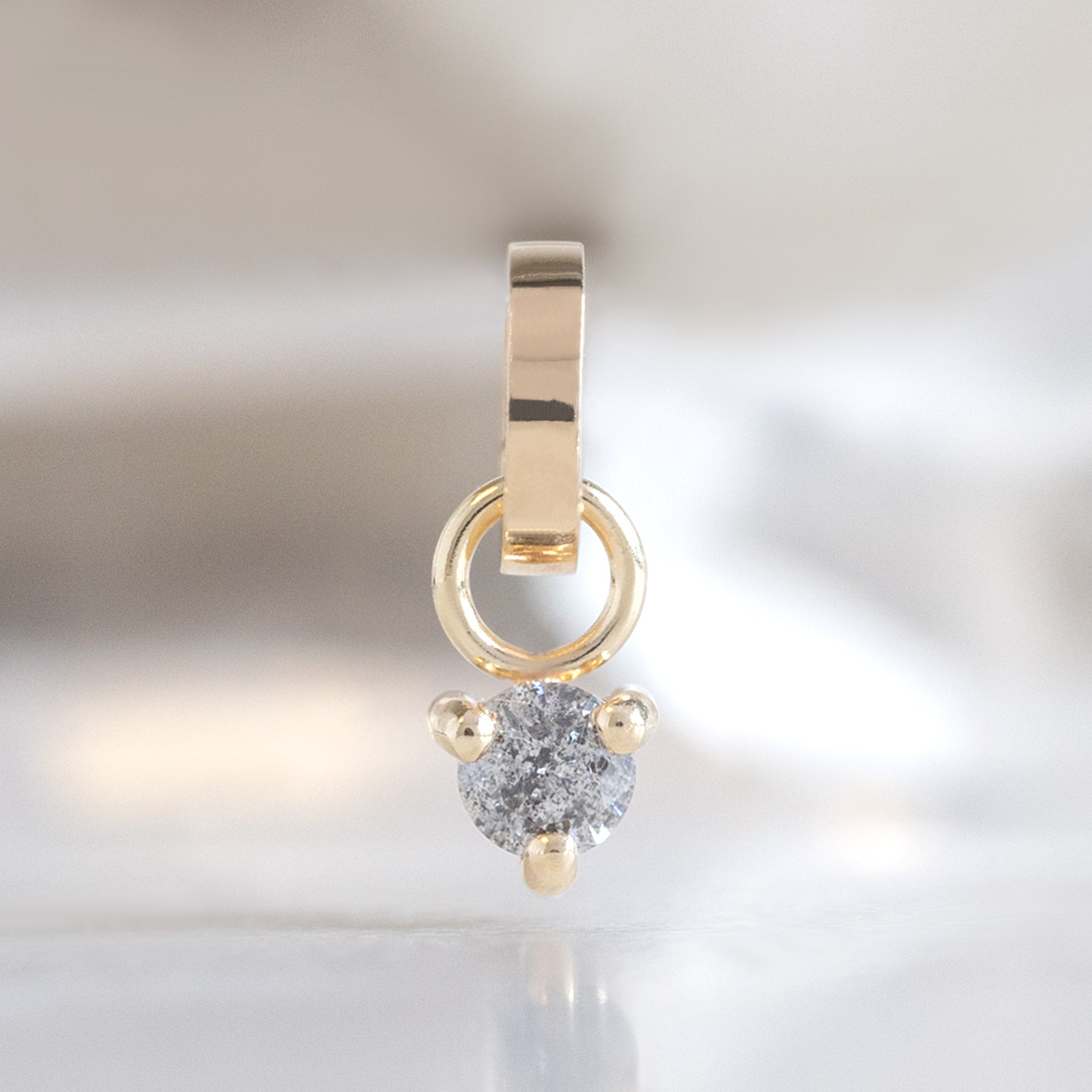 The Salt and Pepper Diamond Birthstone Charm in 10K Yellow Gold on White Marble