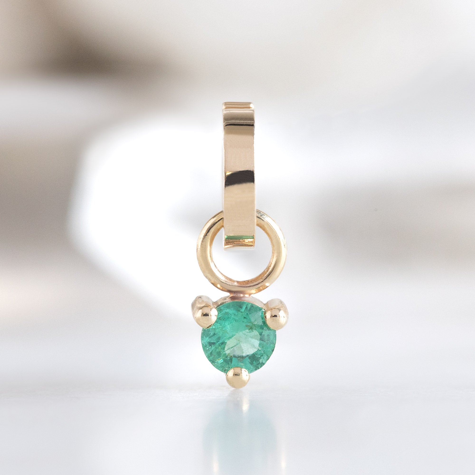 The Emerald Birthstone Charm in 10K Yellow Gold on White Marble