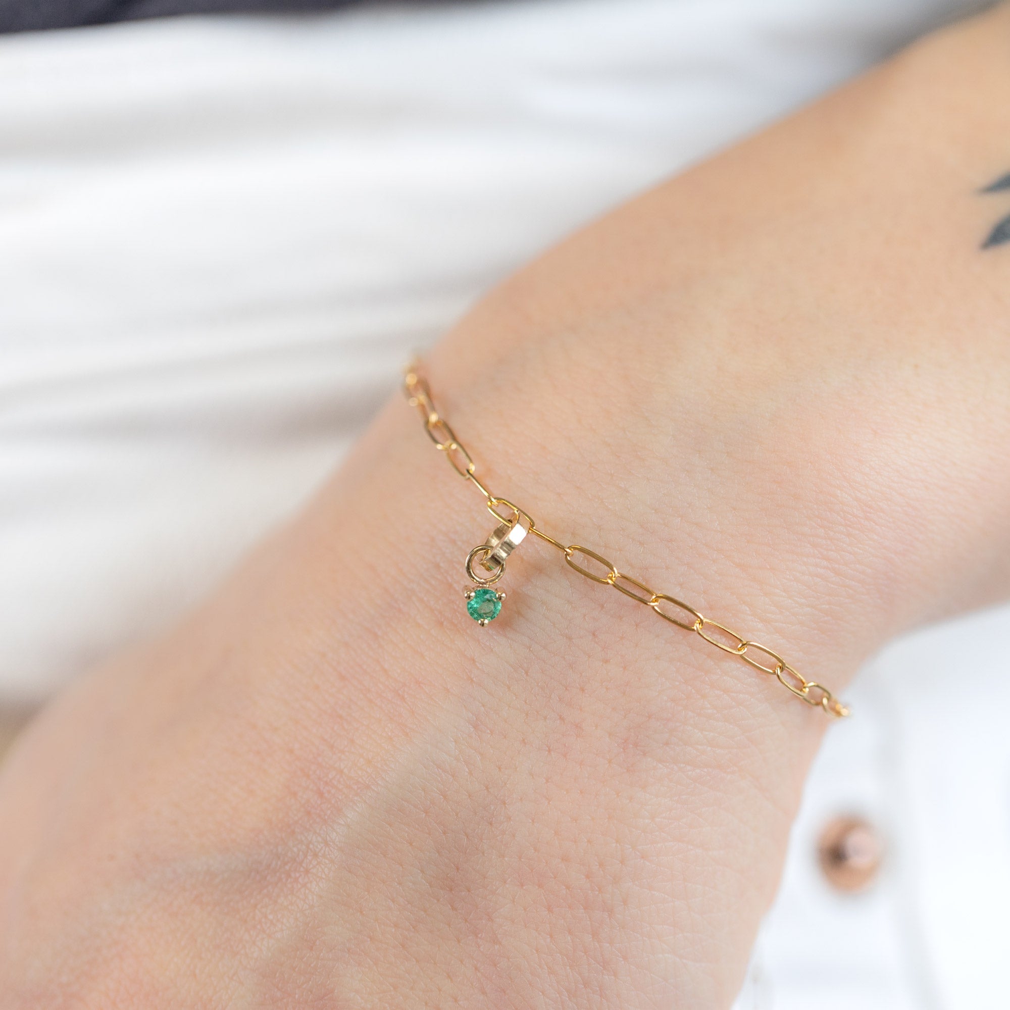 The Emerald Birthstone Charm in 10K Yellow Gold on Drawn Cable Chain Bracelet on Model