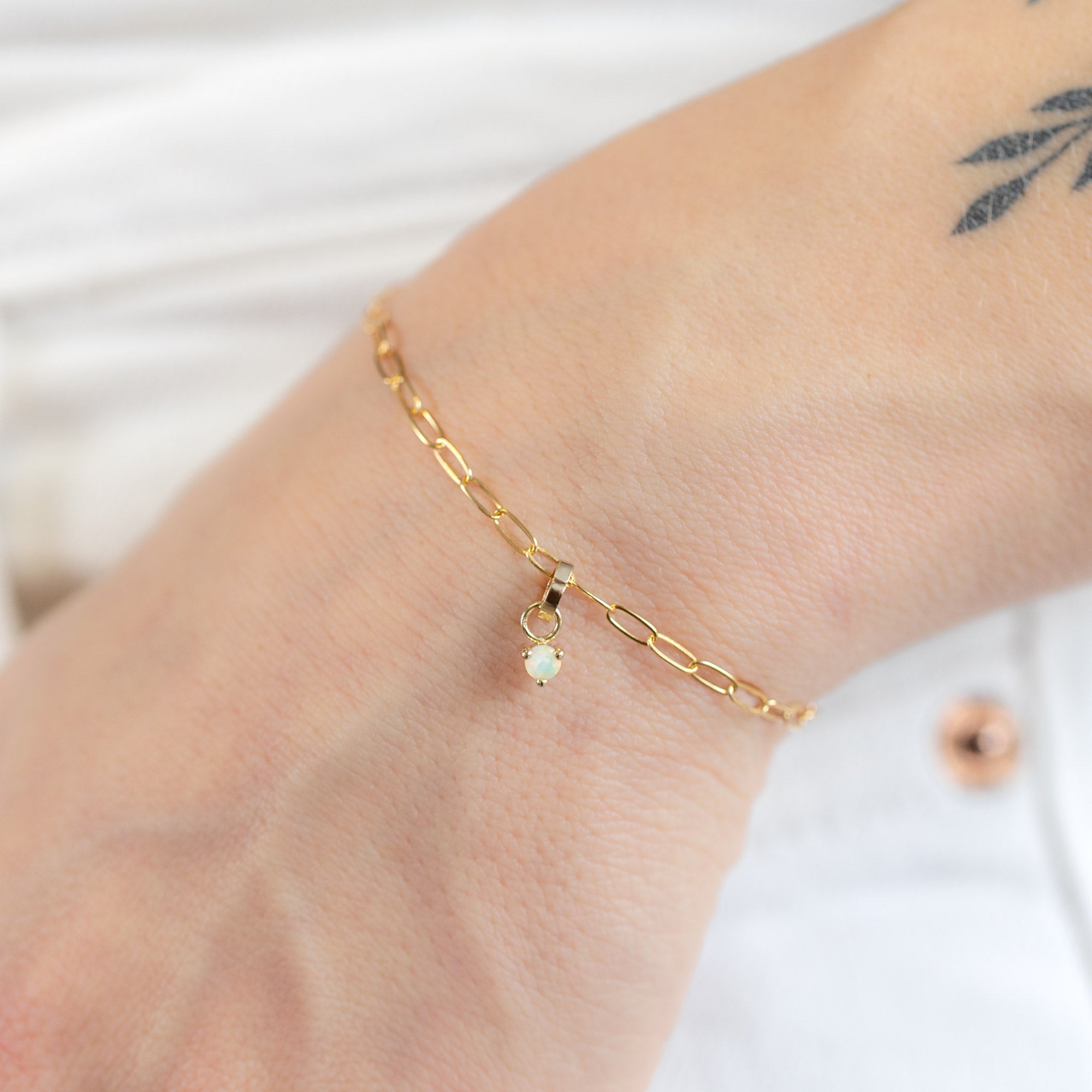 The Opal Birthstone Charm in 10K Yellow Gold on Drawn Cable Chain Bracelet on Model