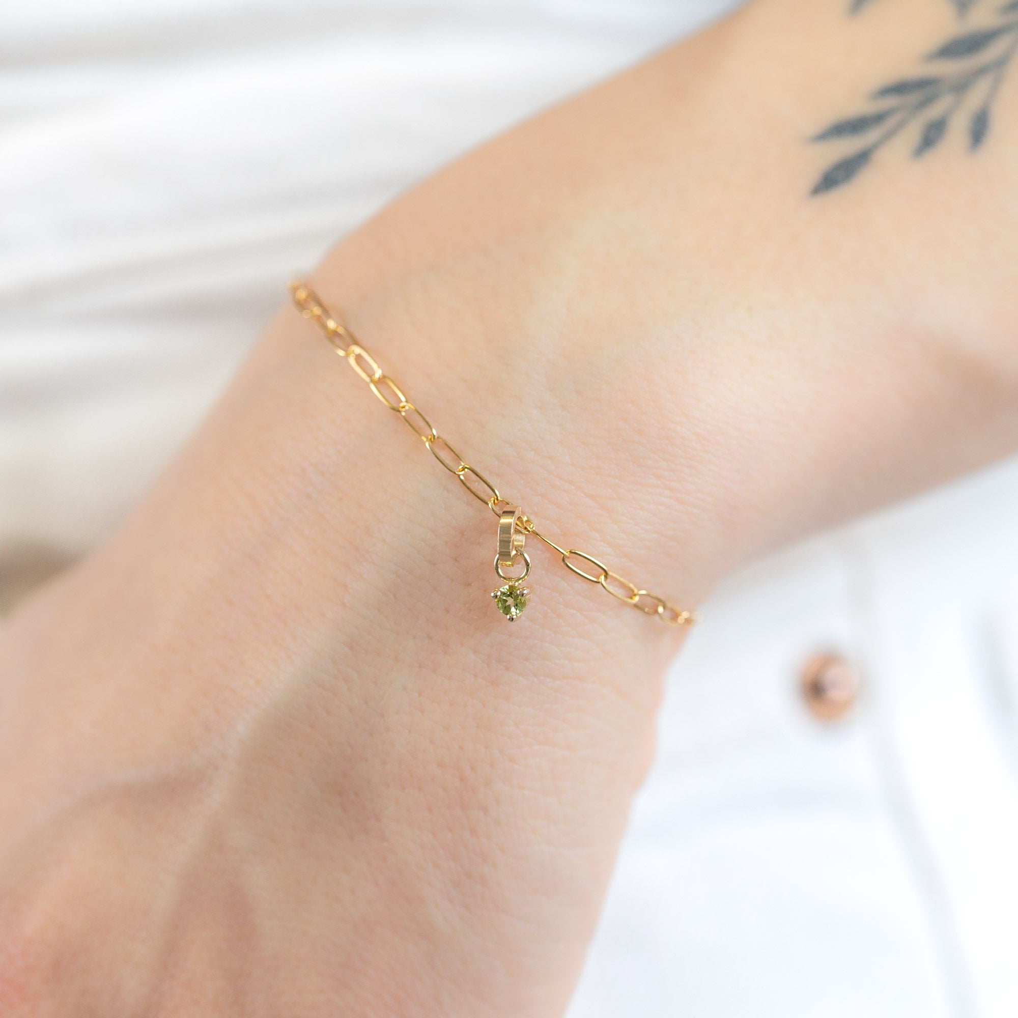 The Peridot Birthstone Charm in 10K Yellow Gold on Drawn Cable Chain Bracelet on Model