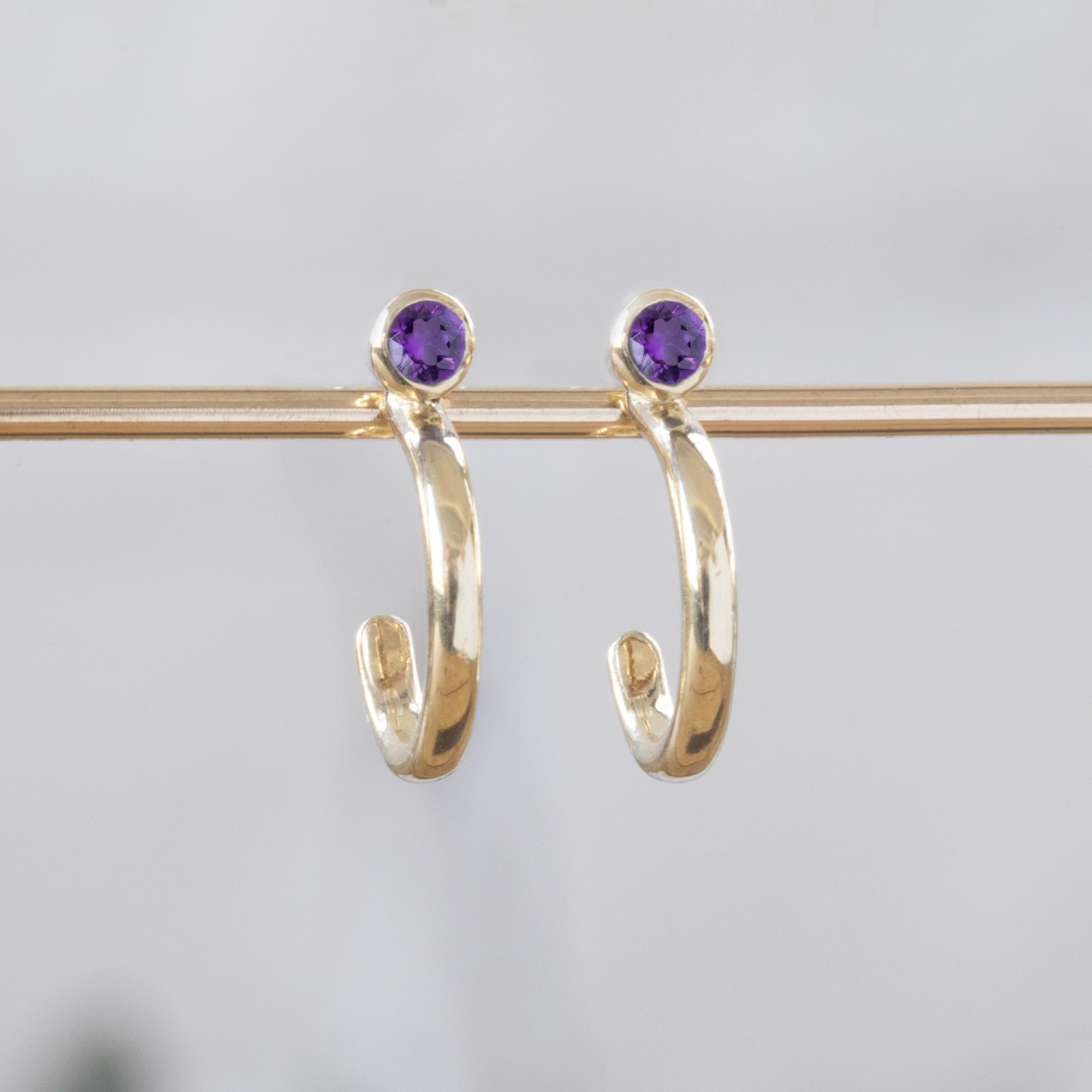 Custom Amethyst Birthstone Hoop Earrings | 14K Yellow Gold.
Displayed on bar