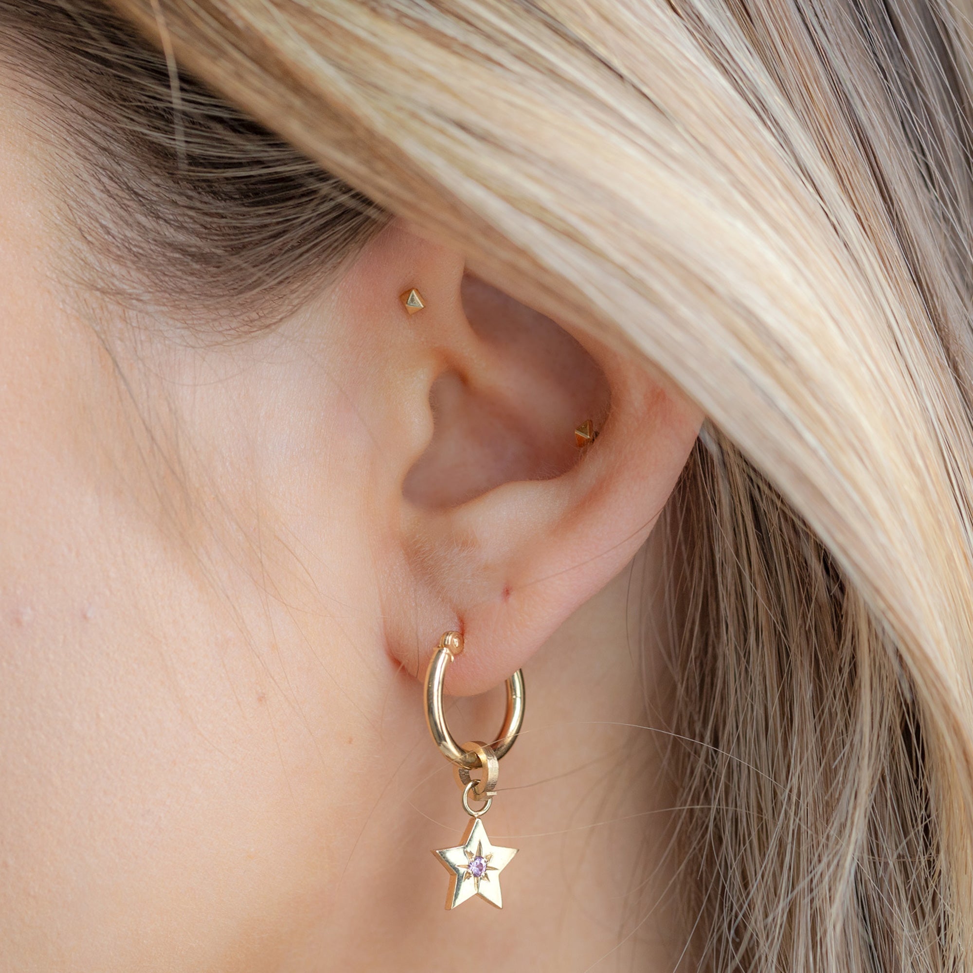 The Charm Hoop Earrings in 14K Yellow Gold with the Pink Sapphire Star Charm on Model