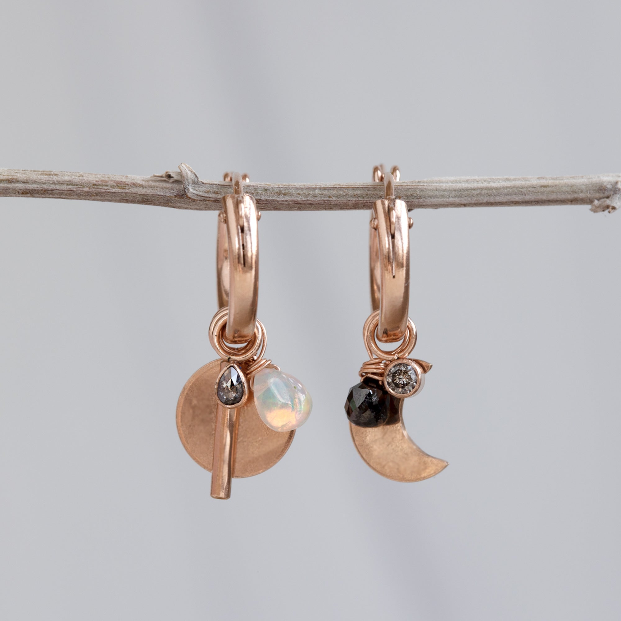 Custom Charm Hoop Earrings | Rose Gold Filled displayed on holding bar with grey background.