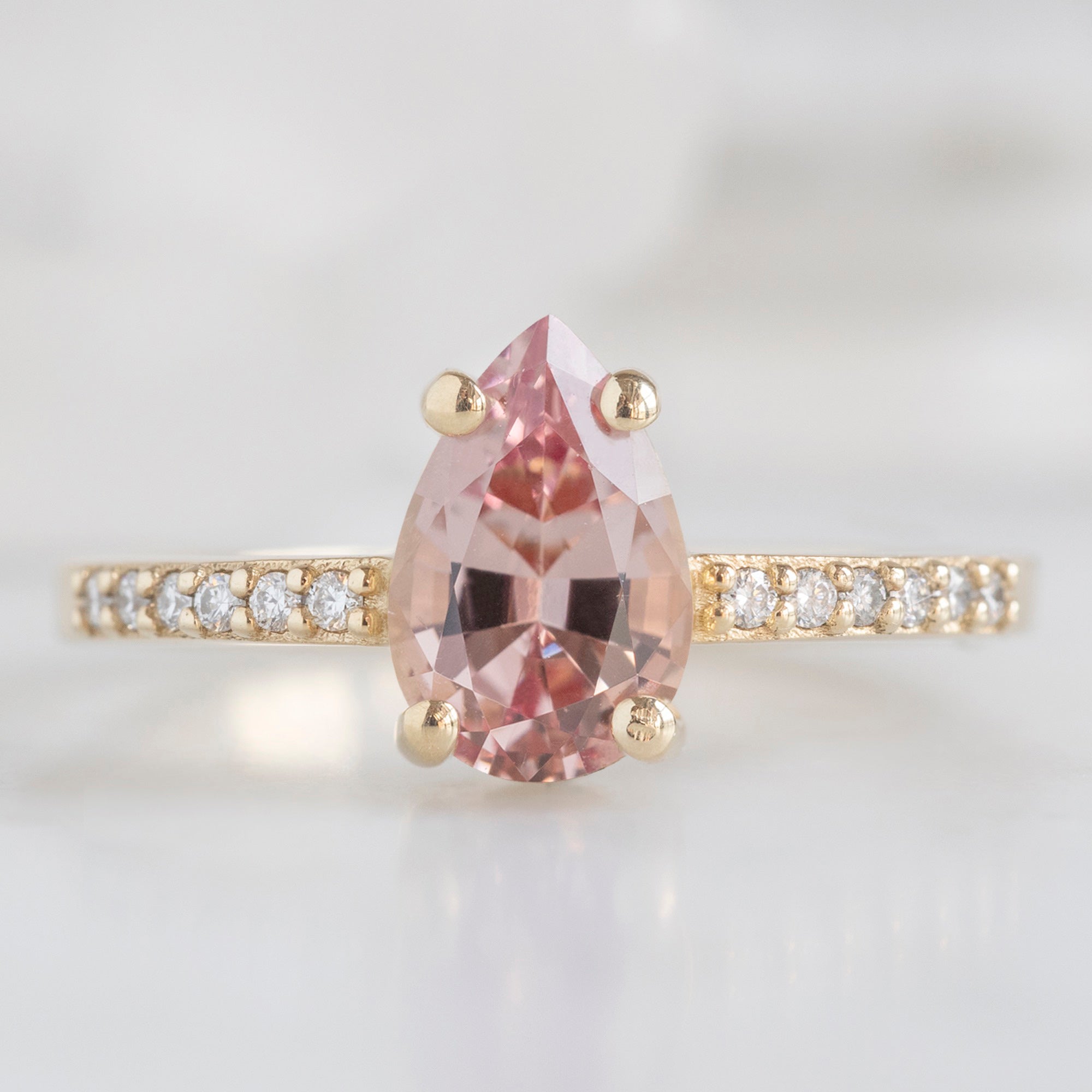 The Willow Ring with a 1.00ct Pear Garnet in 14K Yellow Gold on White Marble