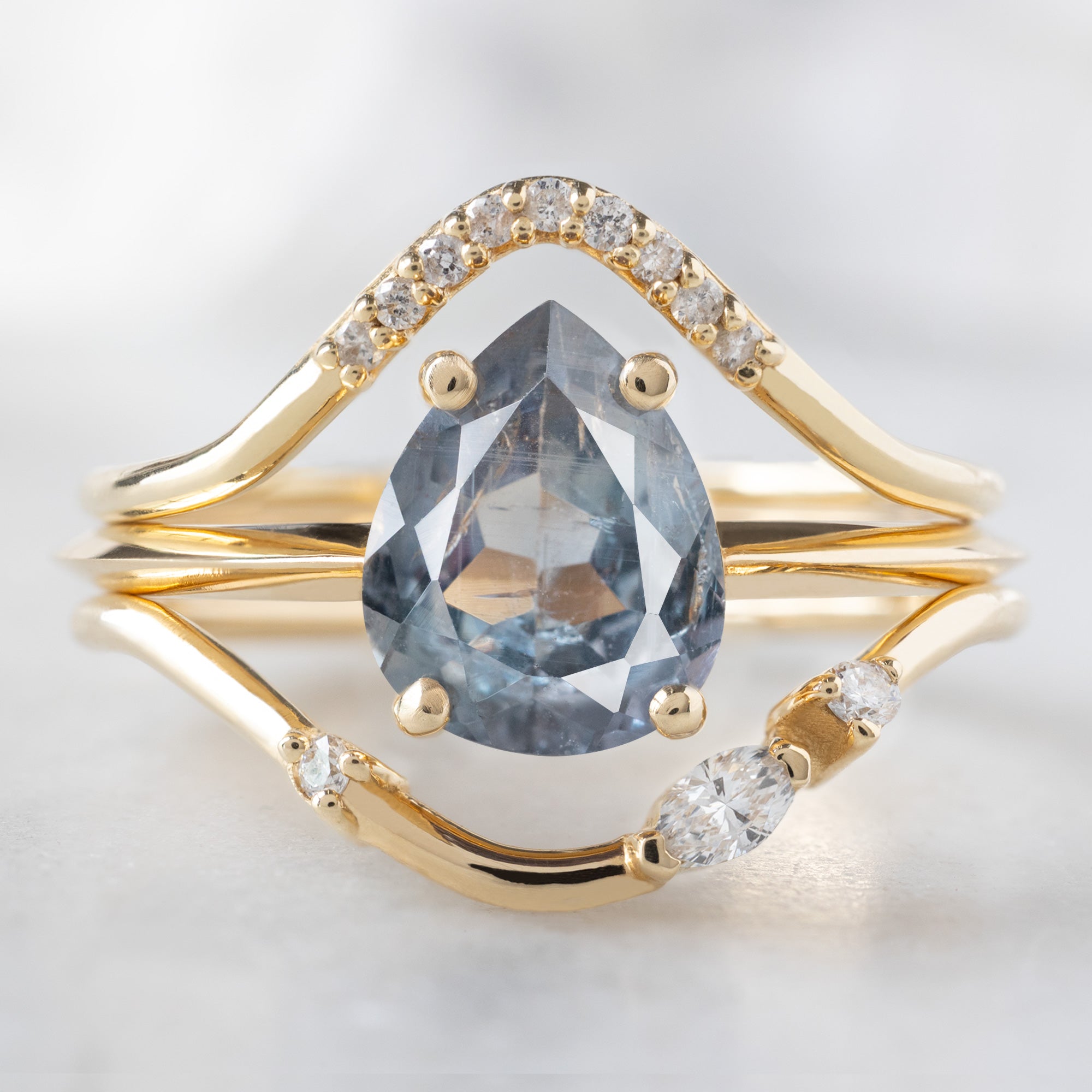 buy:white-diamond-pave-peak-stacking-band-14k-or-18k-yellow-gold,the-bryn-ring-1-42ct-pear-cut-blue-sapphire-in-14k-yellow-gold,asymmetrical-marquise-diamond-arc-stacking-band-in-14k-yellow-gold
