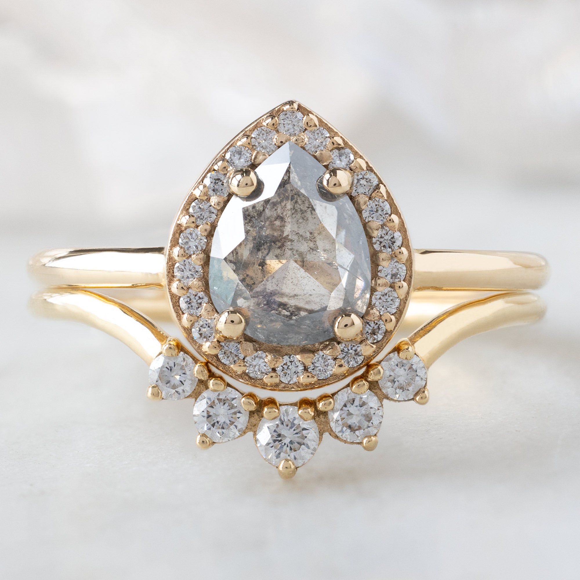 The Dahlia Ring with a 0.90ct Pear Grey Diamond in 14K Yellow Gold Stacked with the Round White Diamond Sunburst Stacking Band