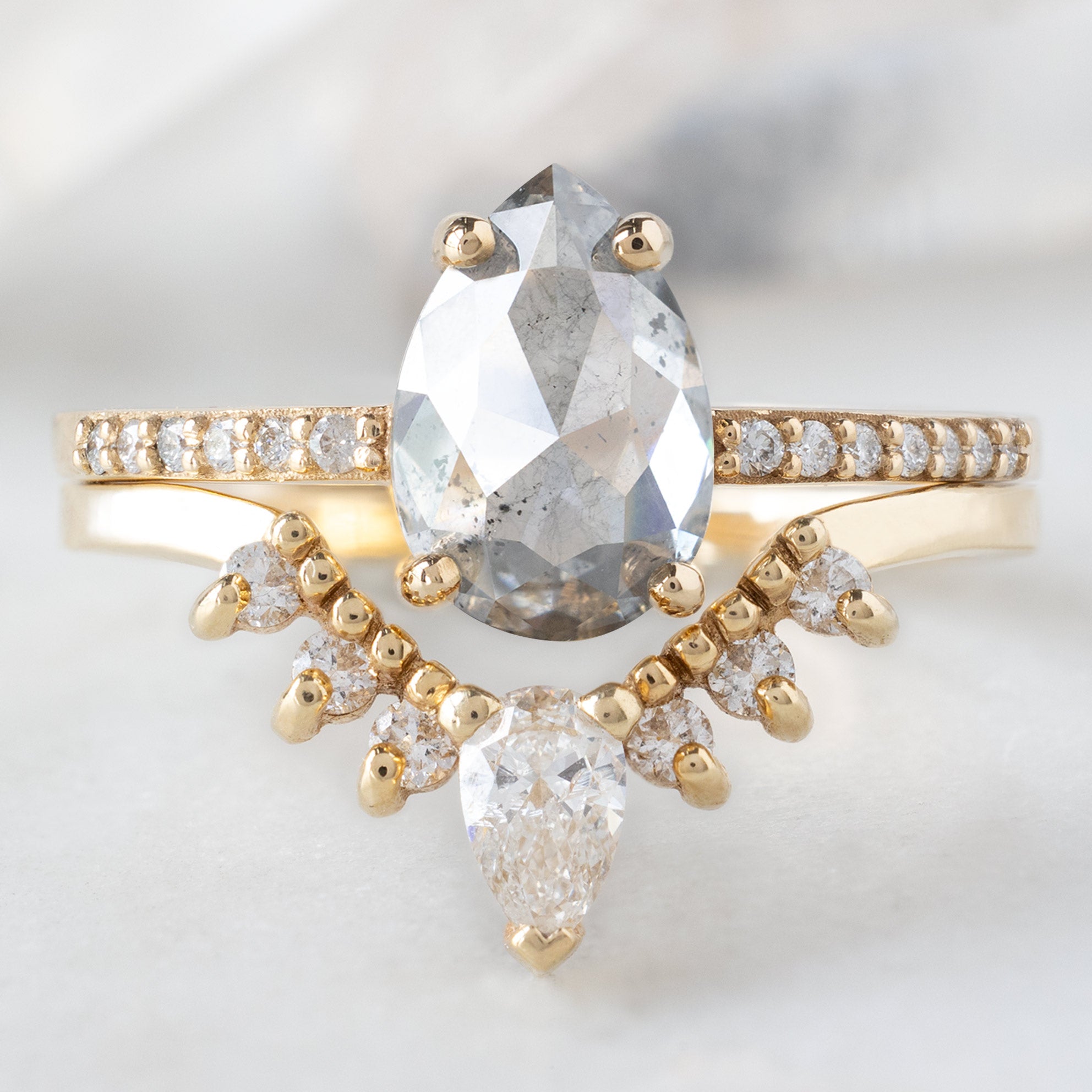 The Willow Ring with a 1.52ct Pear Salt and Pepper Diamond in 14K Yellow Gold Stacked with the White Diamond Sunburst Stacking Band