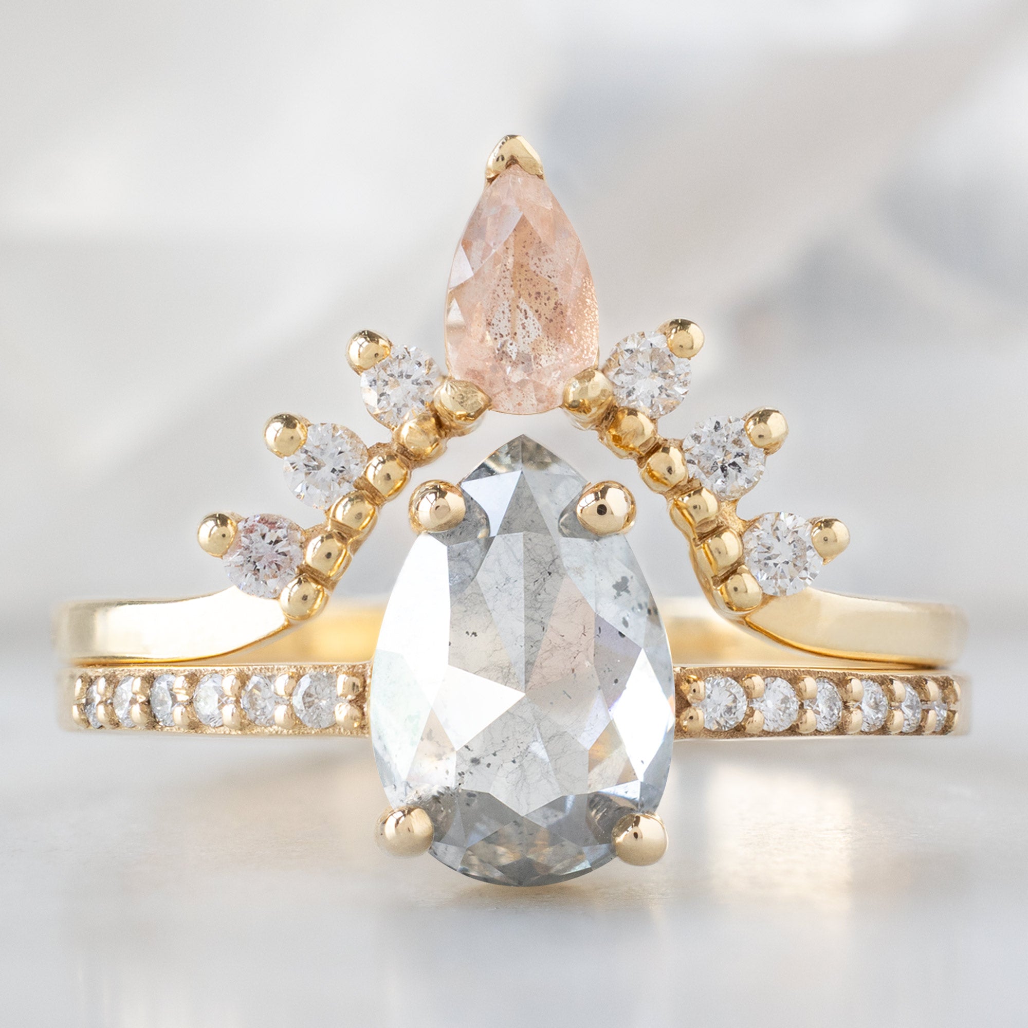 The Willow Ring with a 1.52ct Pear Salt and Pepper Diamond in 14K Yellow Gold Stacked with the Sunstone and White Diamond Sunburst Stacking Band