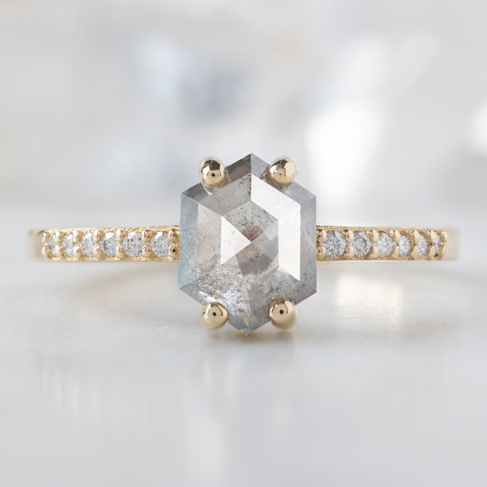 The Willow Ring with a .99ct Hexagon Salt and Pepper Diamond in 14K Yellow Gold on White Marble