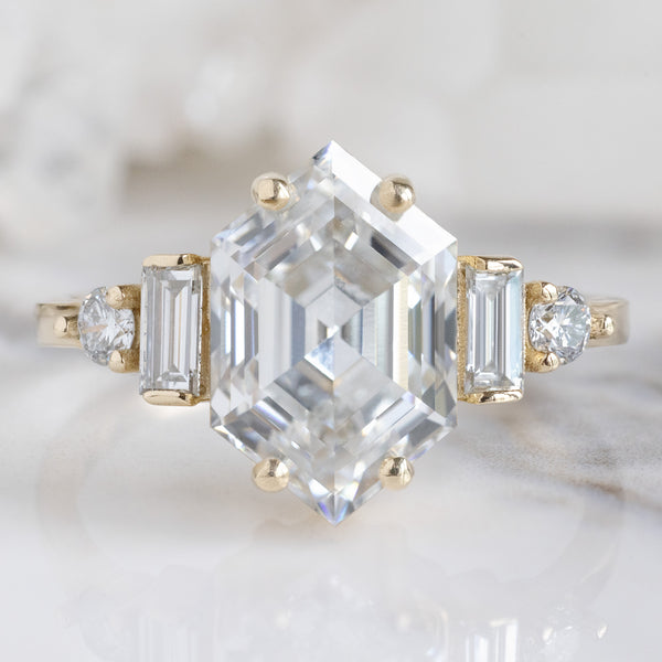 The Primrose Ring with a 2.64ct Hexagon Lab Grown White Diamond in 14K Yellow Gold on White Marble