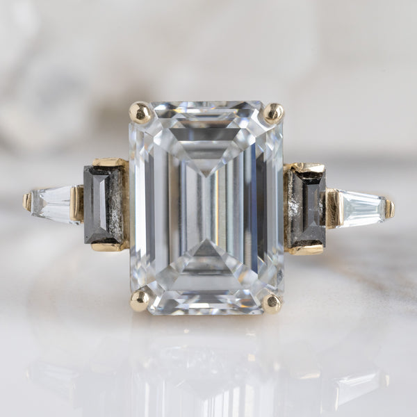 The Deco Ring with a 3.39ct Emerald Cut Lab Grown White Diamond in 14K Yellow Gold on White Marble