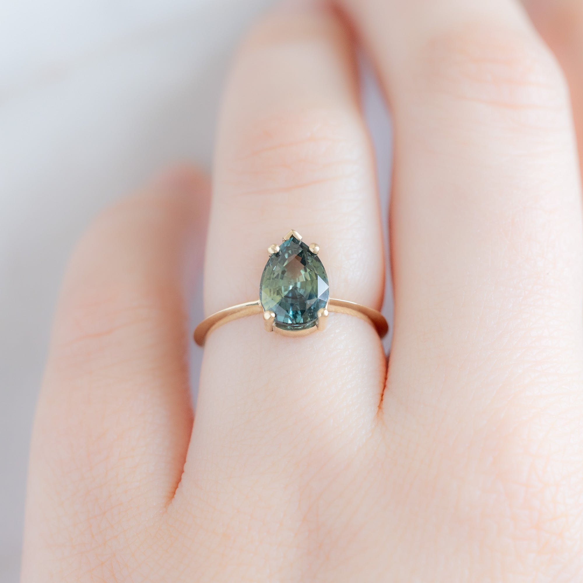 The Sage Ring with a 2.04ct Pear Teal Sapphire in 14 Yellow Gold on Model