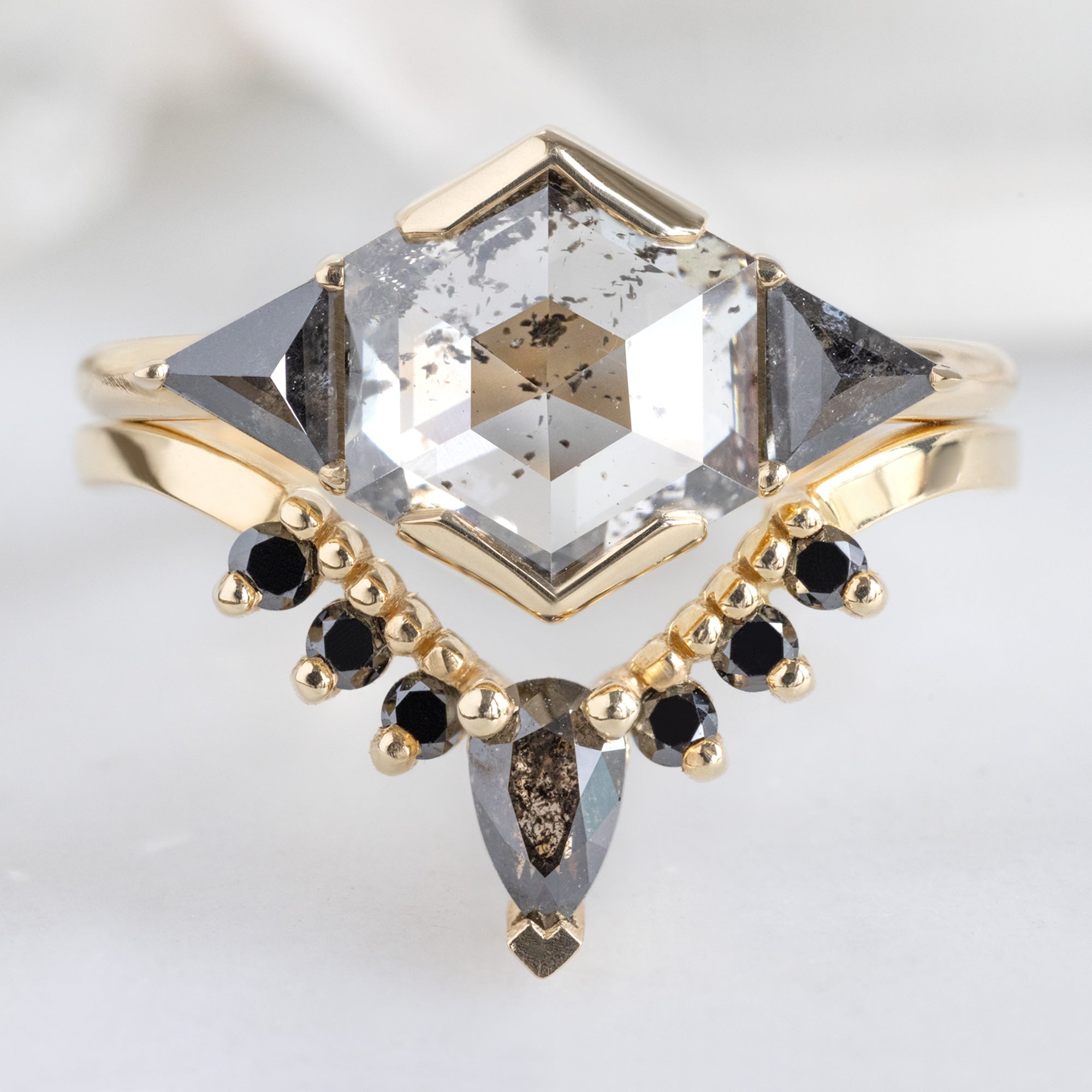 The Jade Ring with a 1.72ct Hexagon Lab Grown Salt and Pepper Diamond in 14K Yellow Gold Stacked with the Black Diamond Sunburst Stacking Band