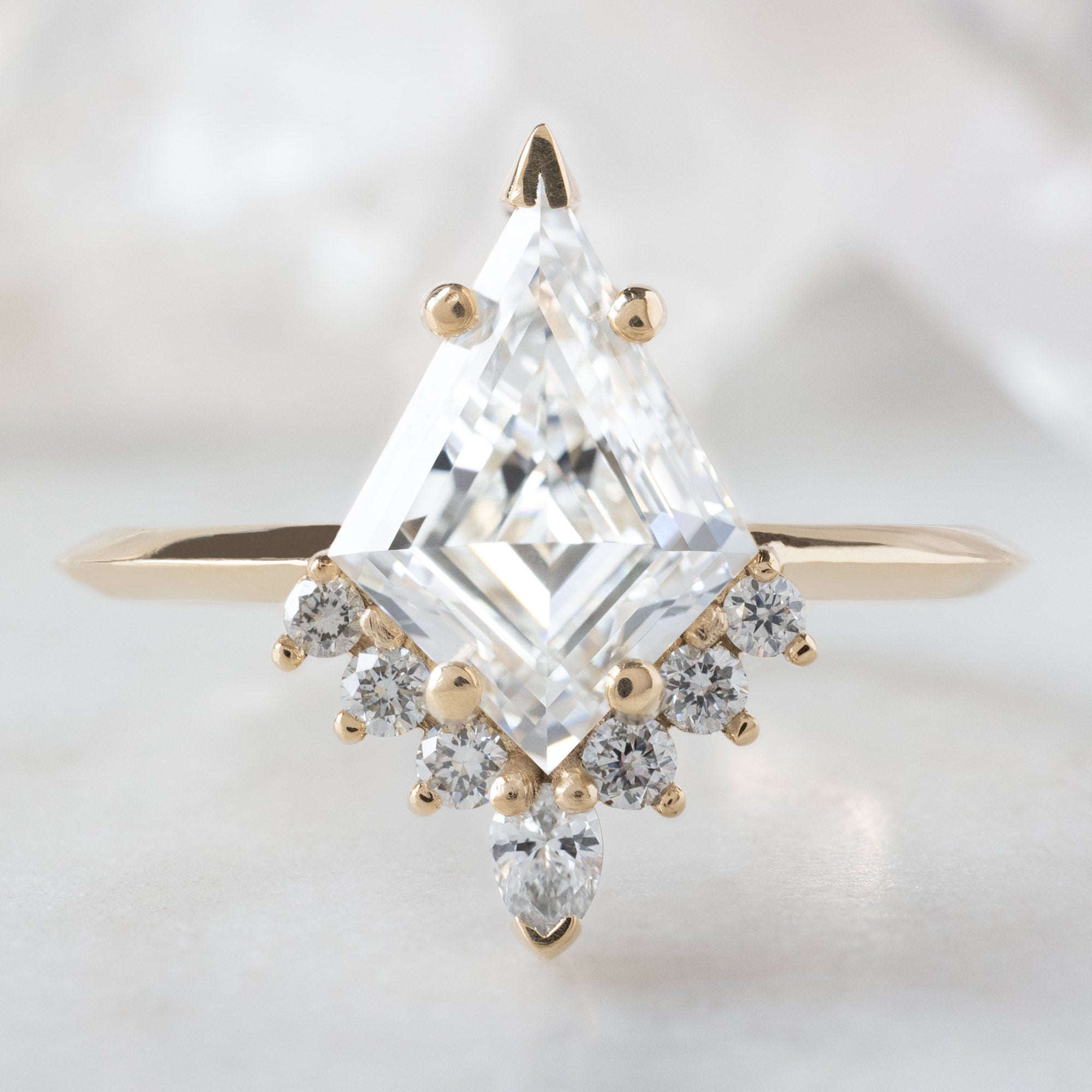 The Aster Ring with a 1.75ct Lab Grown Kite White Diamond in 14K Yellow Gold on White Marble