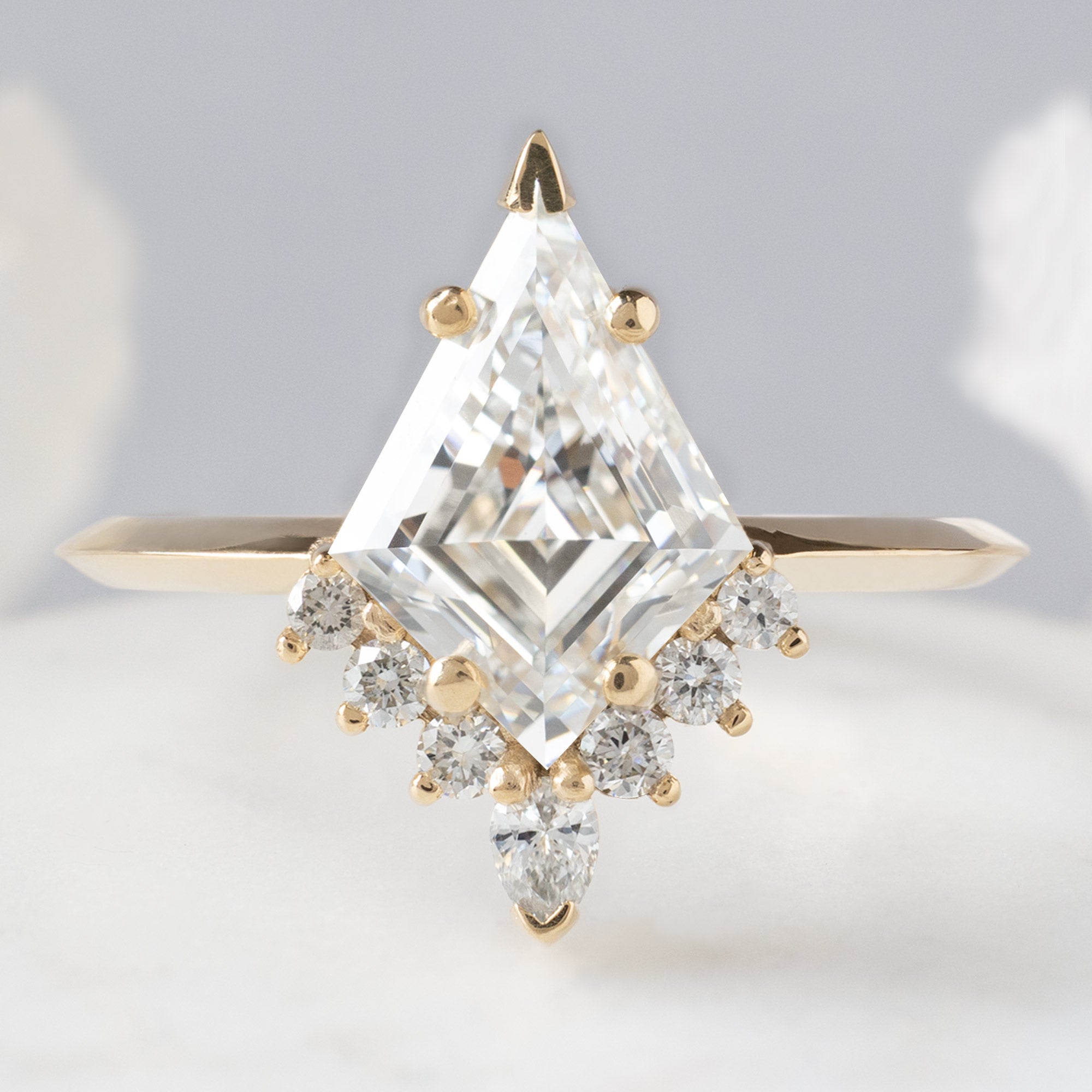 The Aster Ring with a 1.75ct Lab Grown Kite White Diamond in 14K Yellow Gold on White Marble