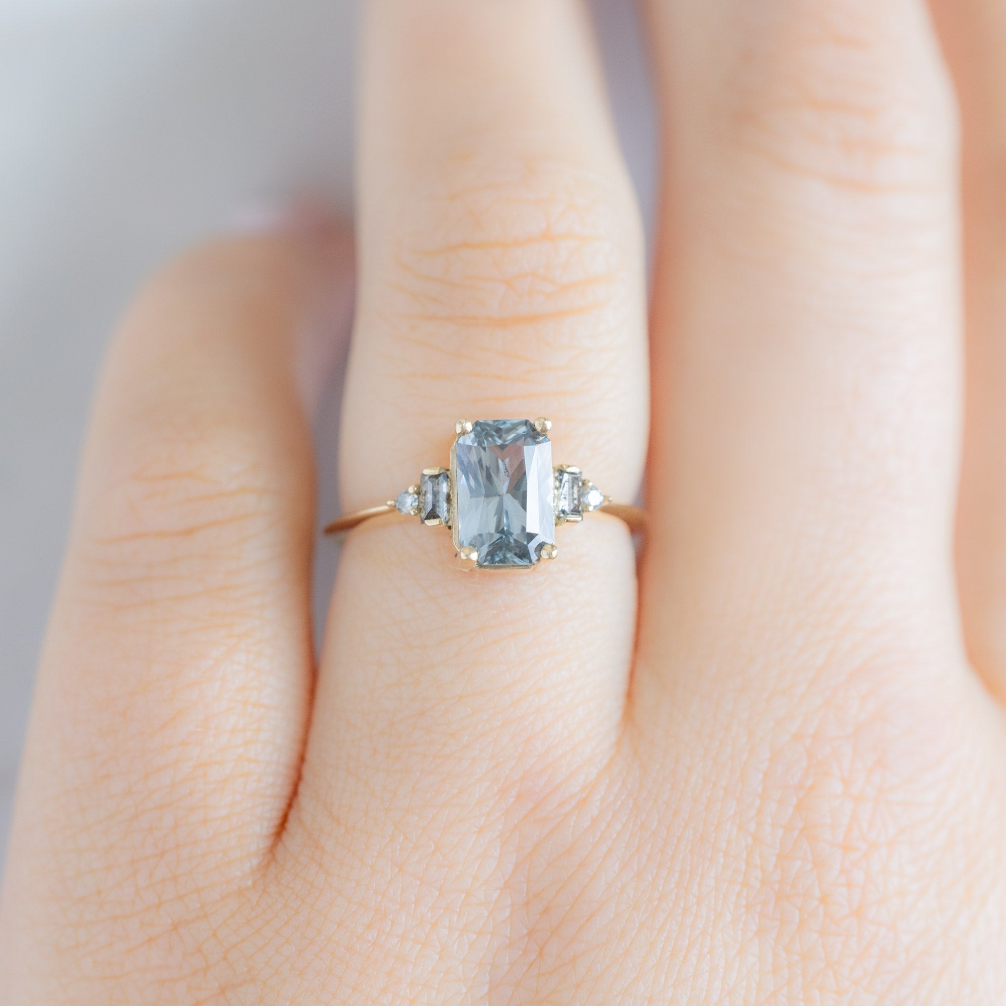 The Primrose Ring with a 2.00ct Emerald-Cut Blue Sapphire in 14K Yellow Gold on Model