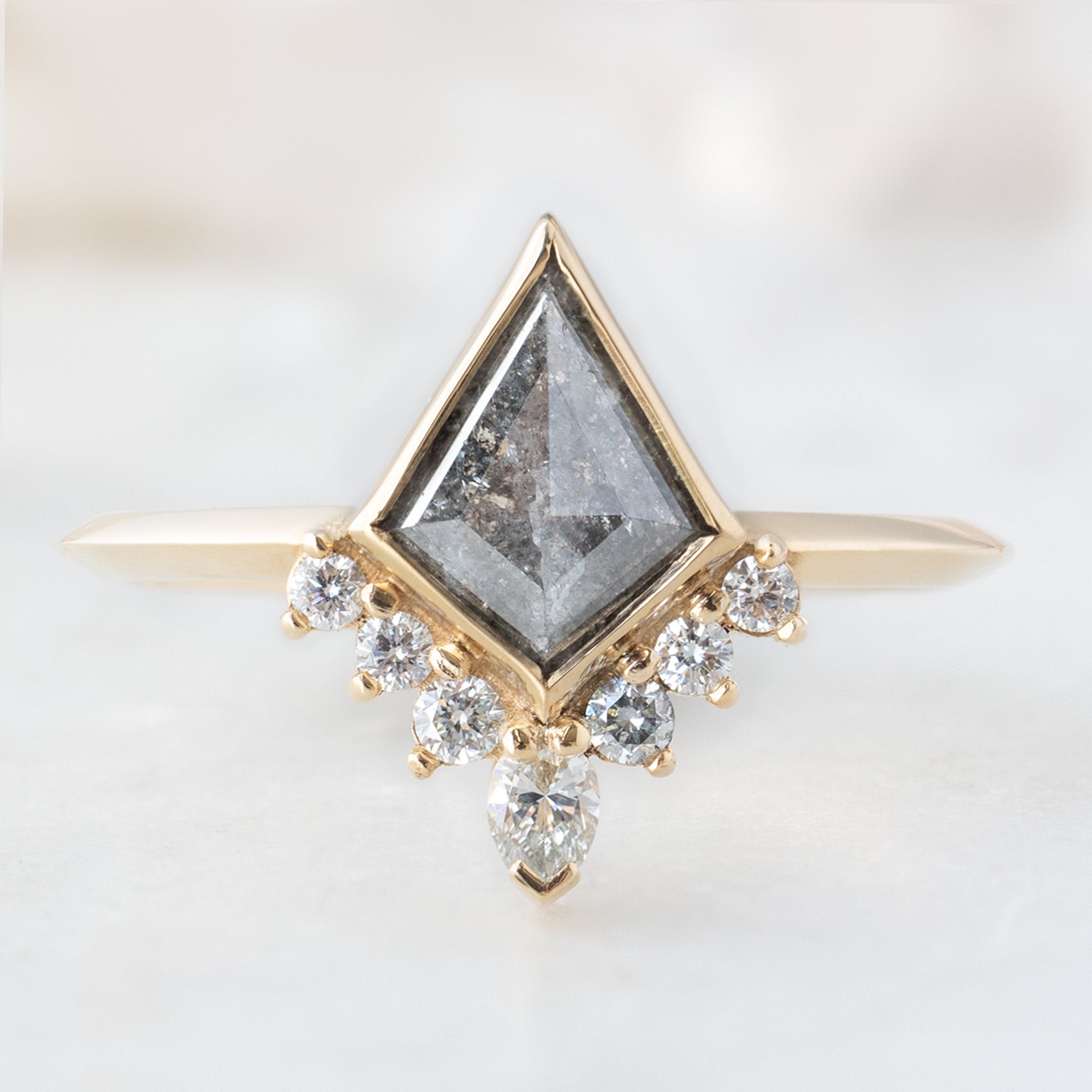 The Aster Ring with a Salt and Pepper Kite Diamond in 14K Yellow Gold on White Marble