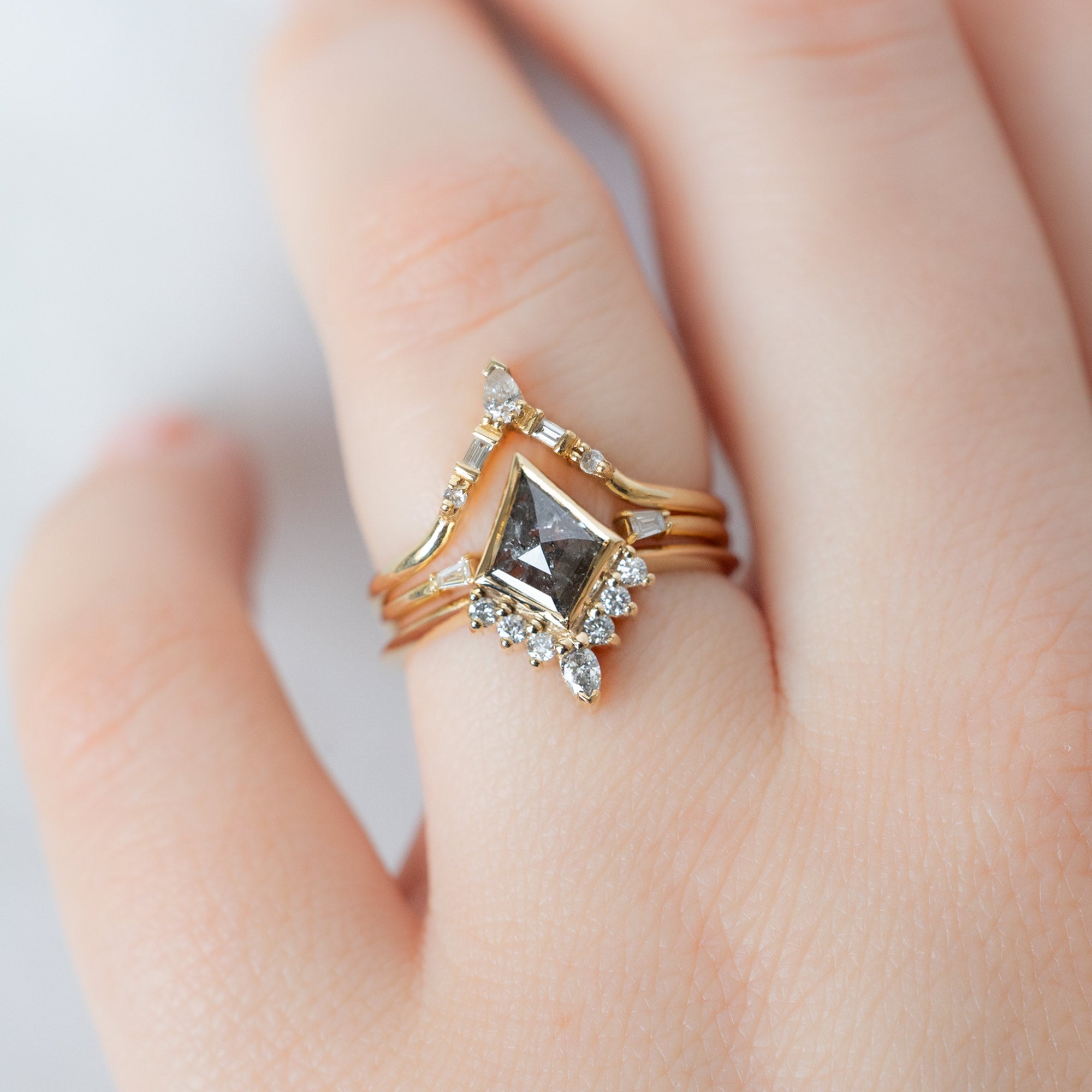 The Aster Ring with a Salt and Pepper Kite Diamond in 14K Yellow Gold Stacked with White Diamond Stacking Bands on Model