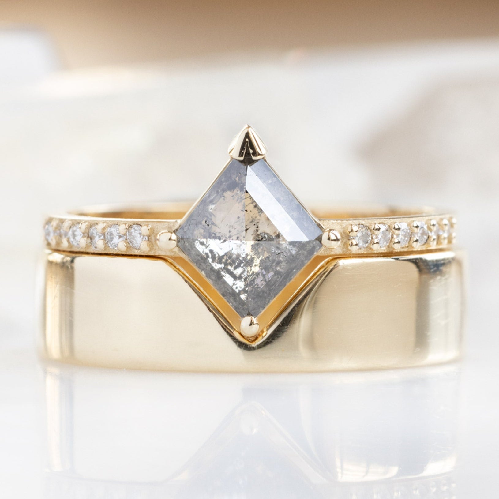 The Willow Ring with a Kite Shaped Salt and Pepper Diamond in 14K Yellow Gold Stacked with the Gold Peak Cut Out Stacking Band