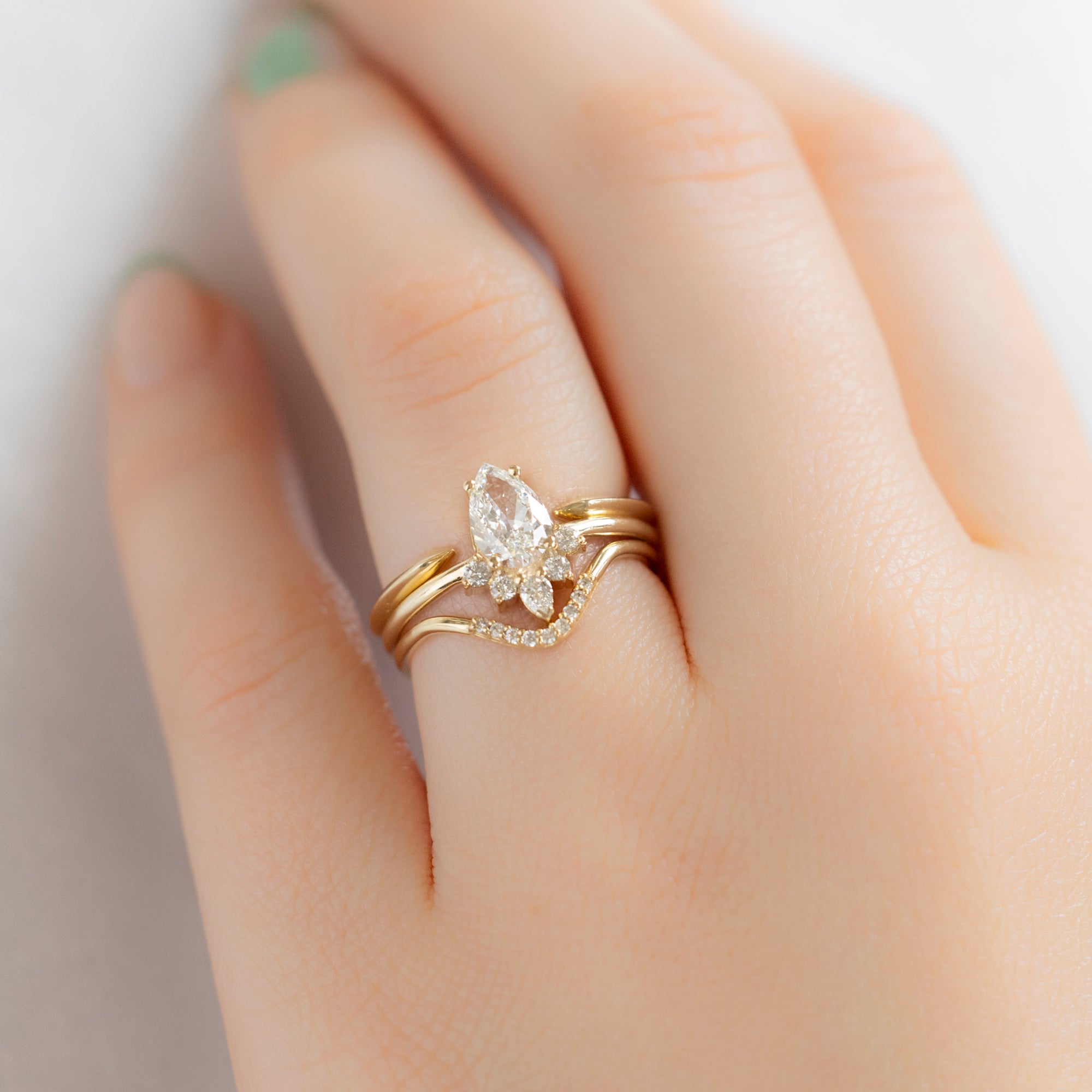 The Aster Ring with a 0.82ct Pear Natural White Diamond in 14K Yellow Gold with Stacking Bands on Model
