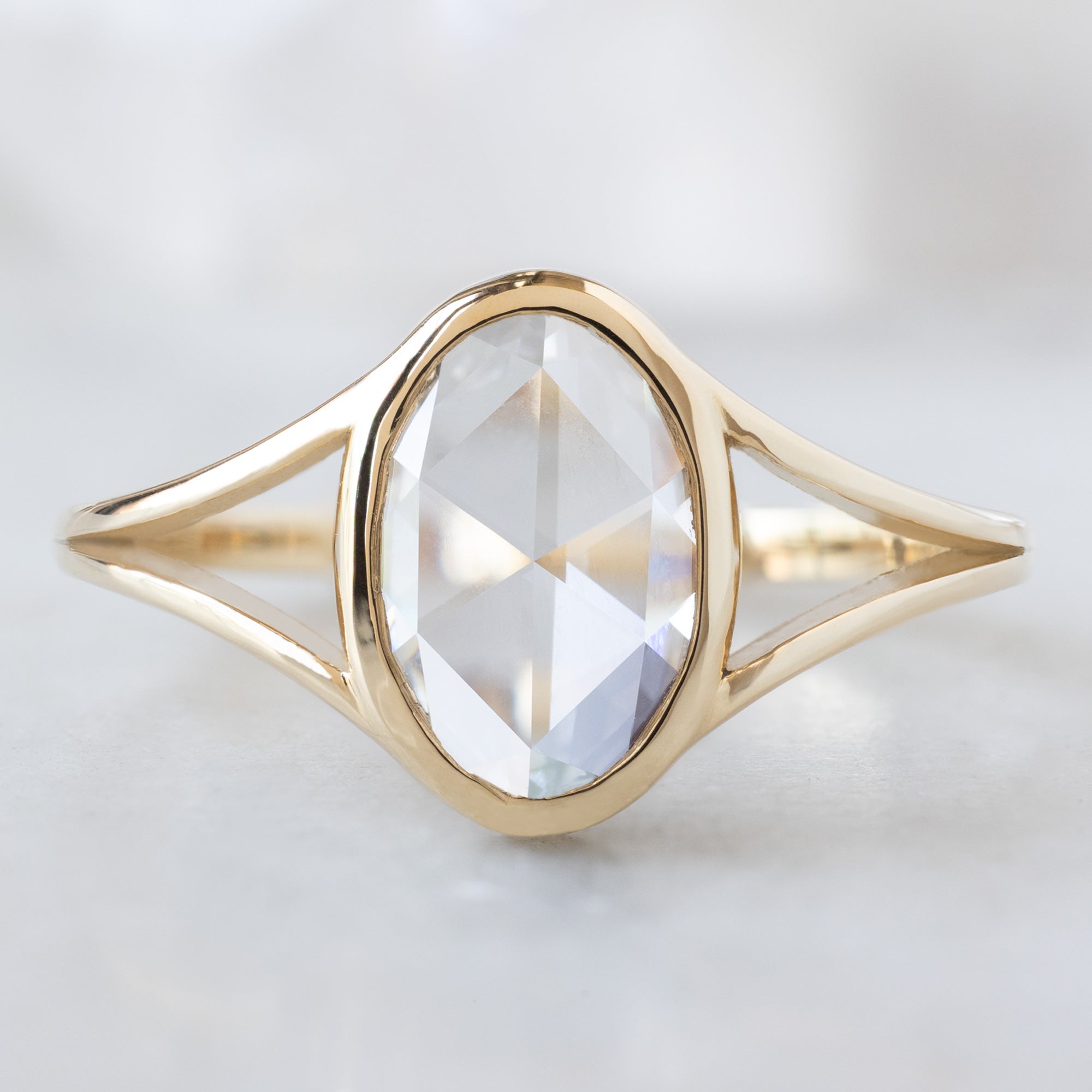 The Magnolia Ring with a 1.26ct Oval Lab Grown White Diamond in 14K Yellow Gold on White Marble