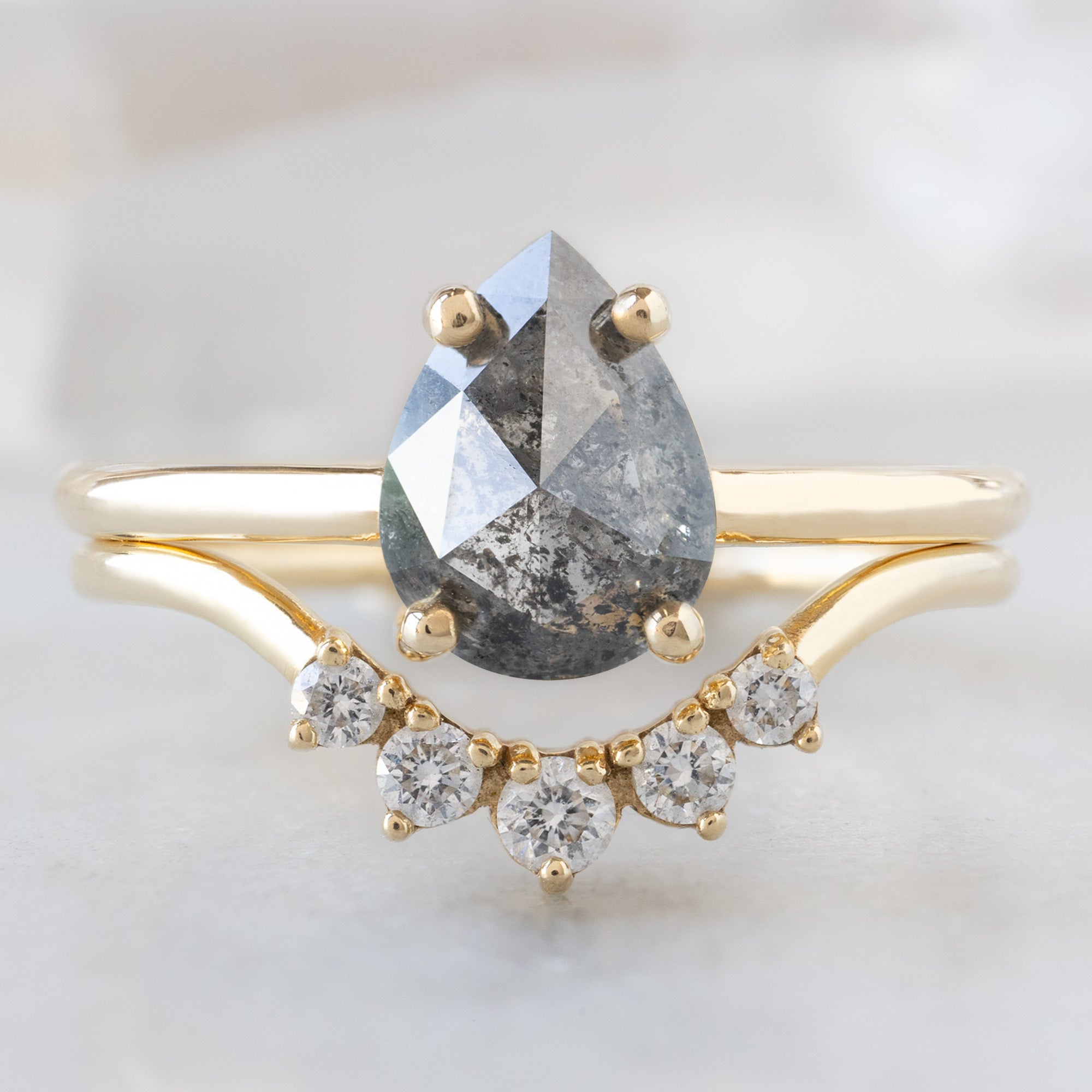 The Bryn Ring with a 1.25ct Pear Salt and Pepper Diamond in 14K Yellow Gold Stacked with the Round White Diamond Sunburst Stacking Band