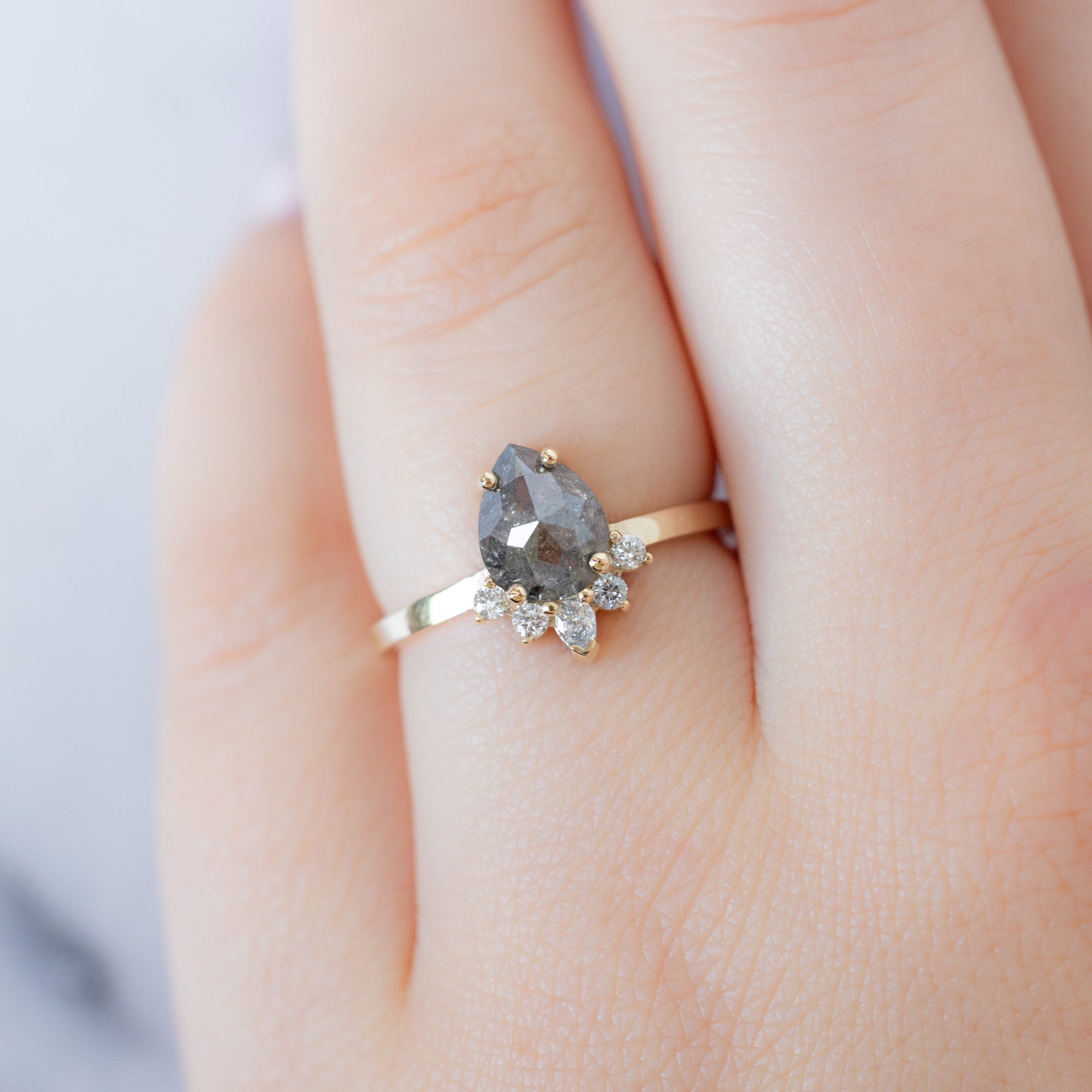 The Aster Ring with a 1.31ct Pear Salt and Pepper Diamond in 14K Yellow Gold on Model's finger