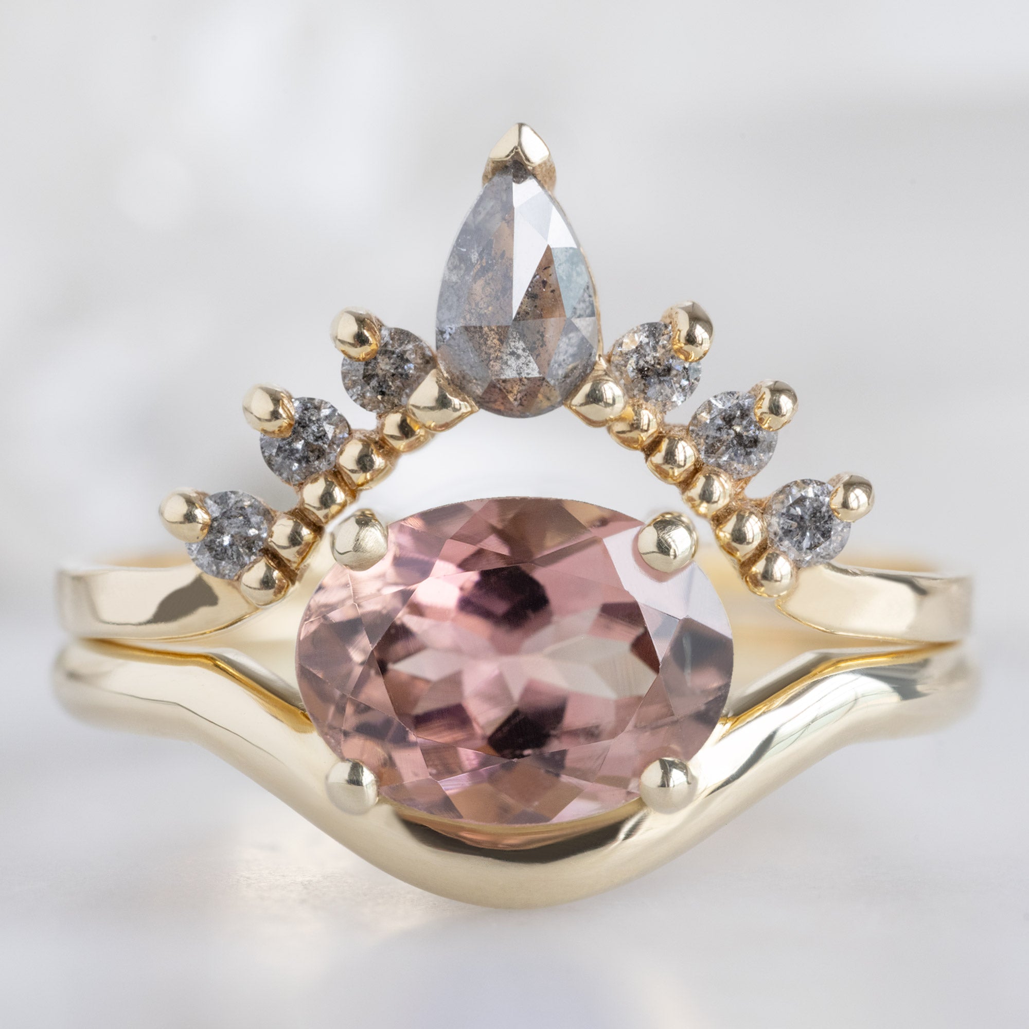 The Wave Ring with a 1.35ct Oval Pink Tourmaline in 14k Yellow Gold Stacked with Salt and Pepper Diamond Sunburst Stacking Band