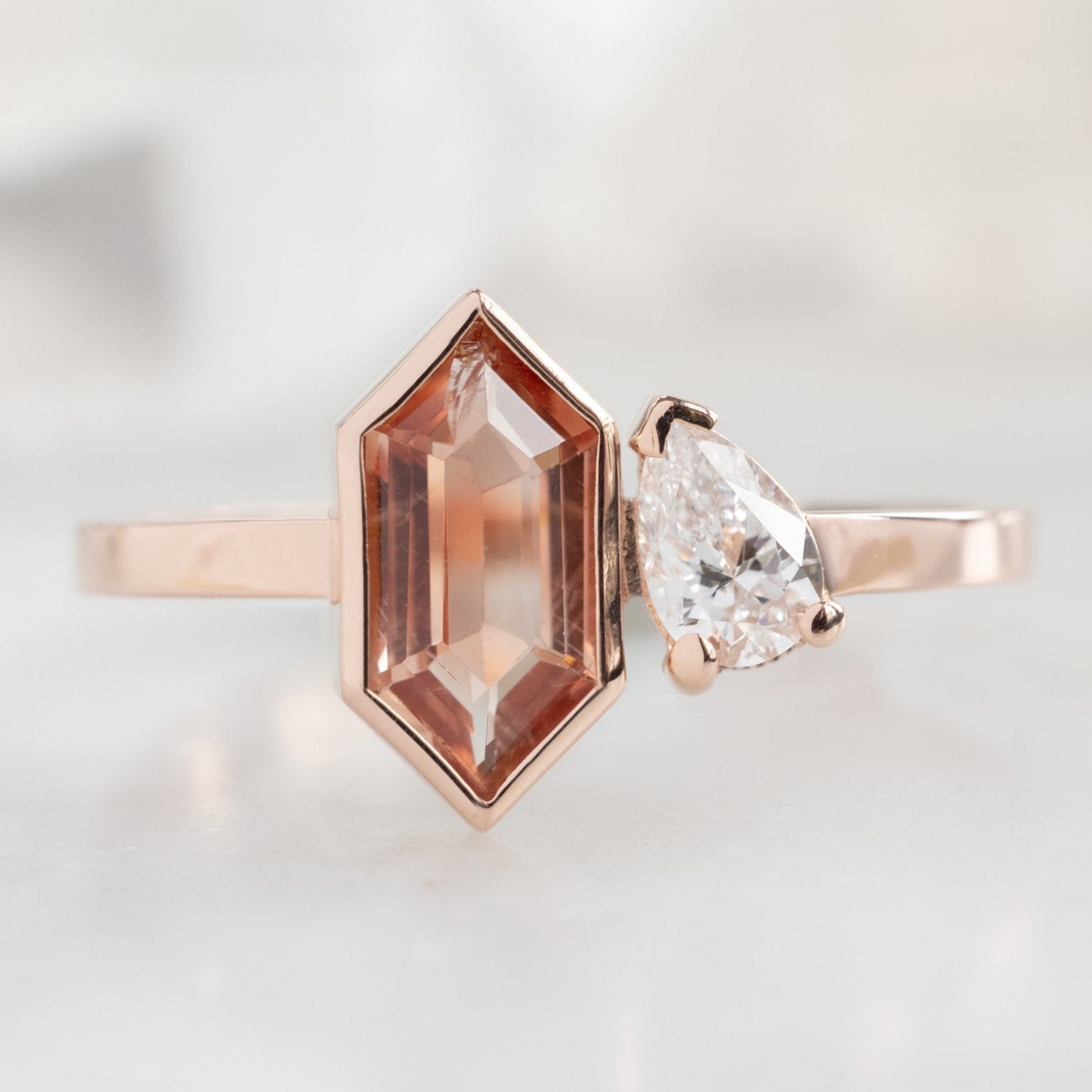 The You and Me Ring with a 0.60ct Hexagon Sunstone in 14K Rose Gold on White Marble Tile