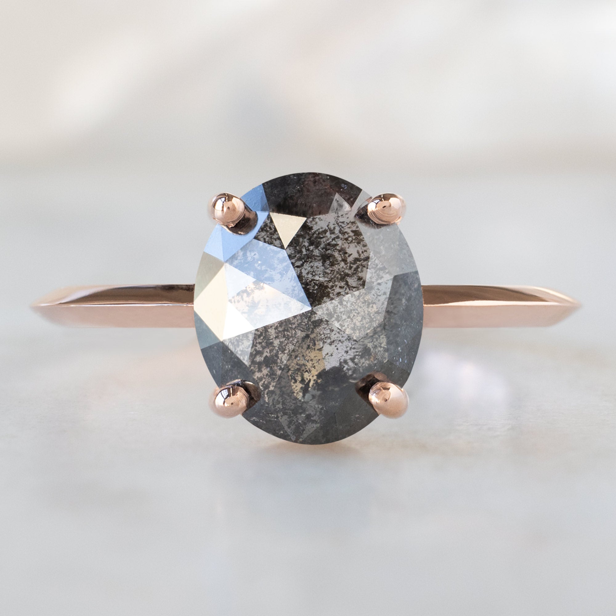 The Bryn Ring with a 1.53ct Oval Salt and Pepper Diamond in 14K Rose Gold on White Marble