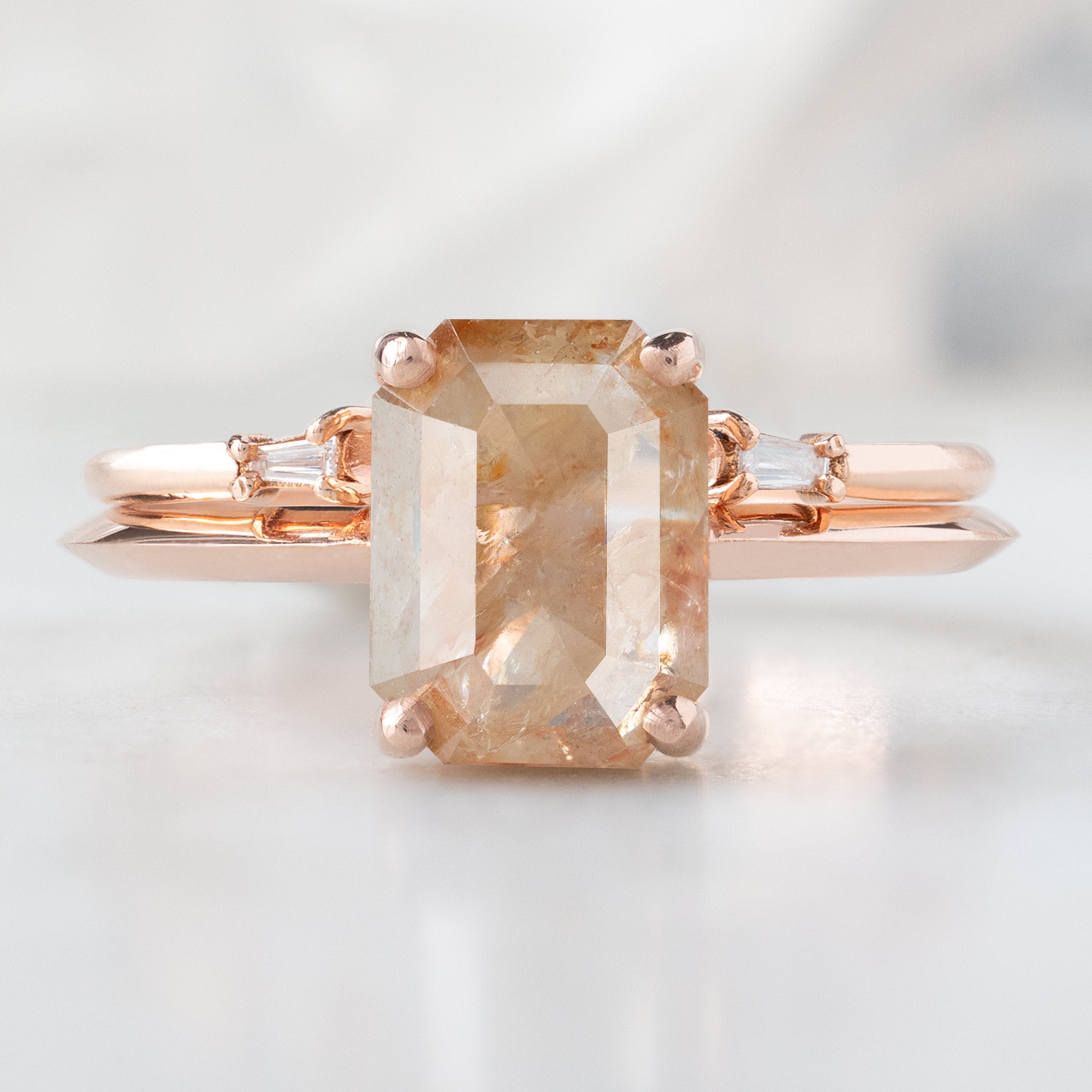The Bryn Ring with an Emerald-Cut Red Diamond in 14K Rose Gold Stacked with the Open Cuff White Baguette Stacking Band