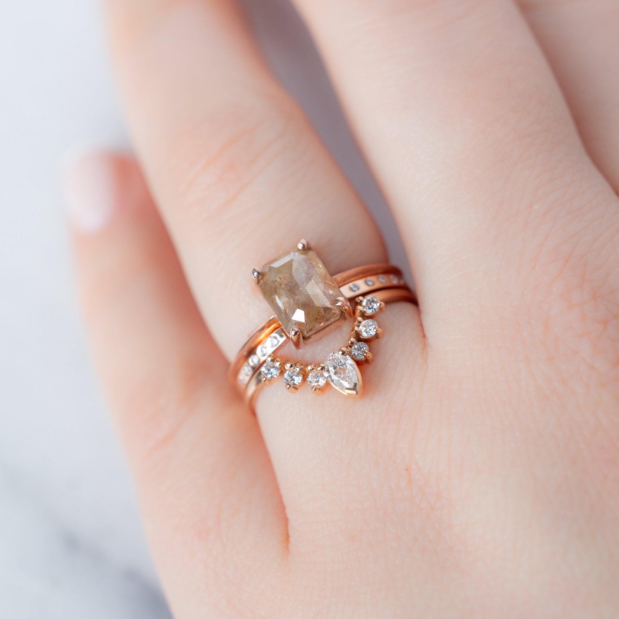 The Bryn Ring with an Emerald-Cut Red Diamond in 14K Rose Gold Stacked with White Diamond Stacking Bands on Model