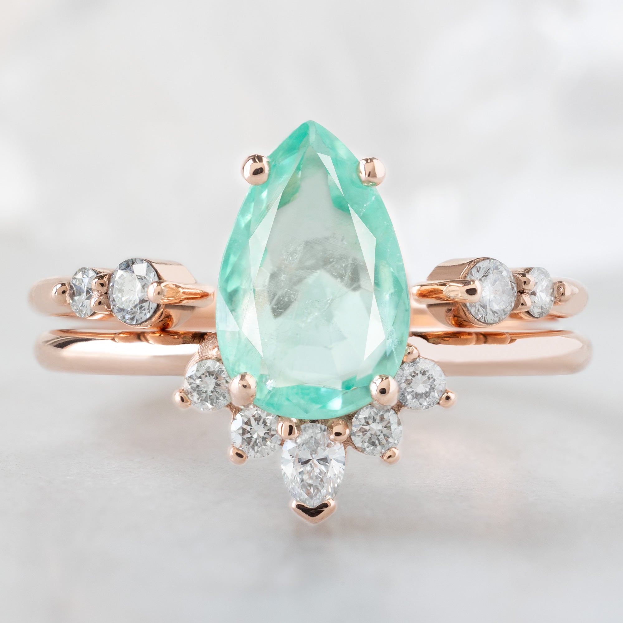 The Aster Ring with a 1.48ct Pear Emerald in 14K Rose Gold Stacked with the Luxe Open Cuff Round White Diamond Stacking Band