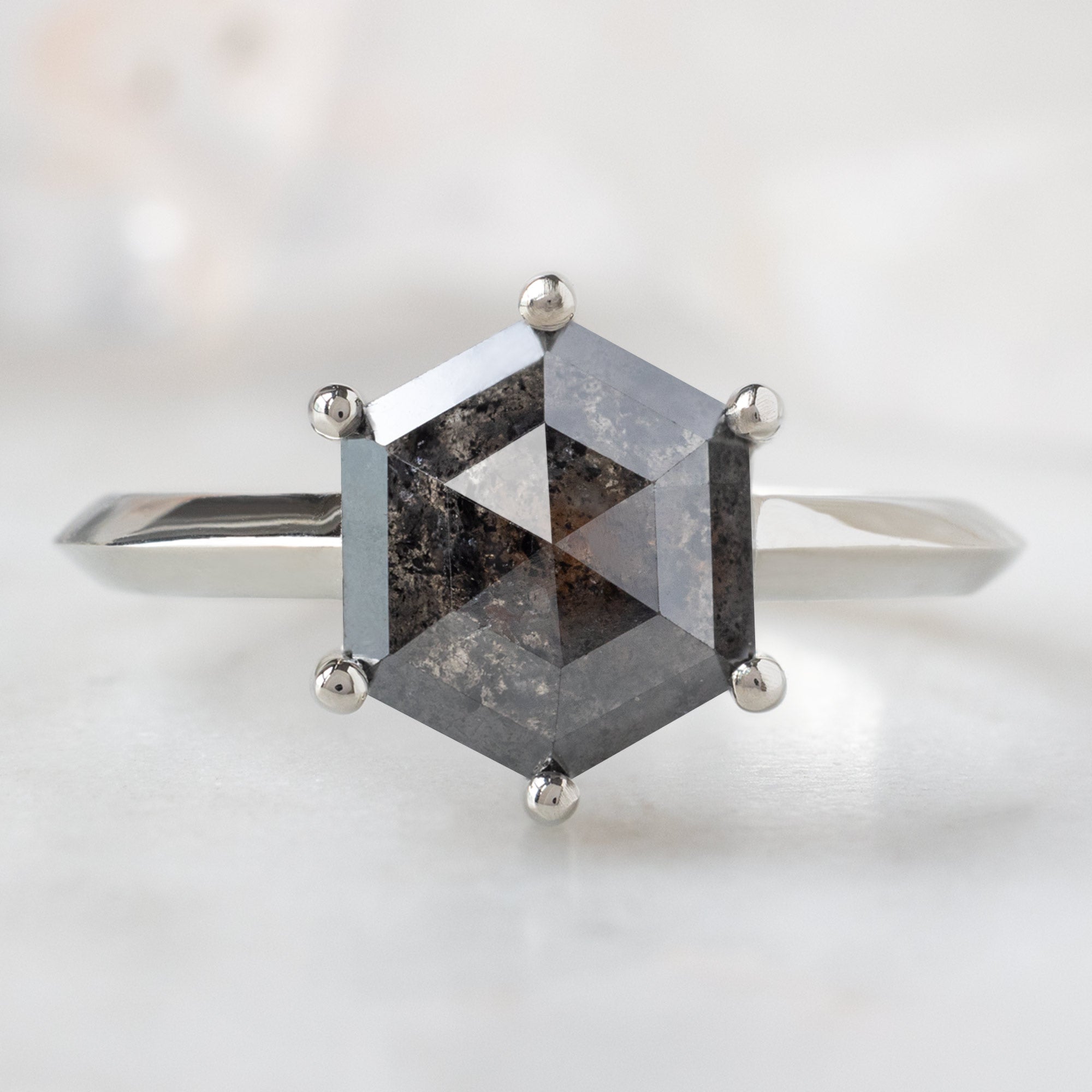 The Bryn Ring with a 2.33ct Black Hexagon Diamond in 14K White Gold on White Marble