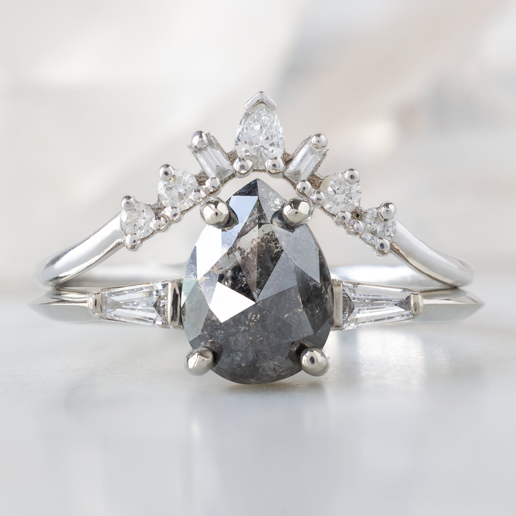 The Ash Ring with a 1.24ct Pear Black Diamond in 14K White Gold Stacked with the Geometric Diamond Sunburst Stacking Band