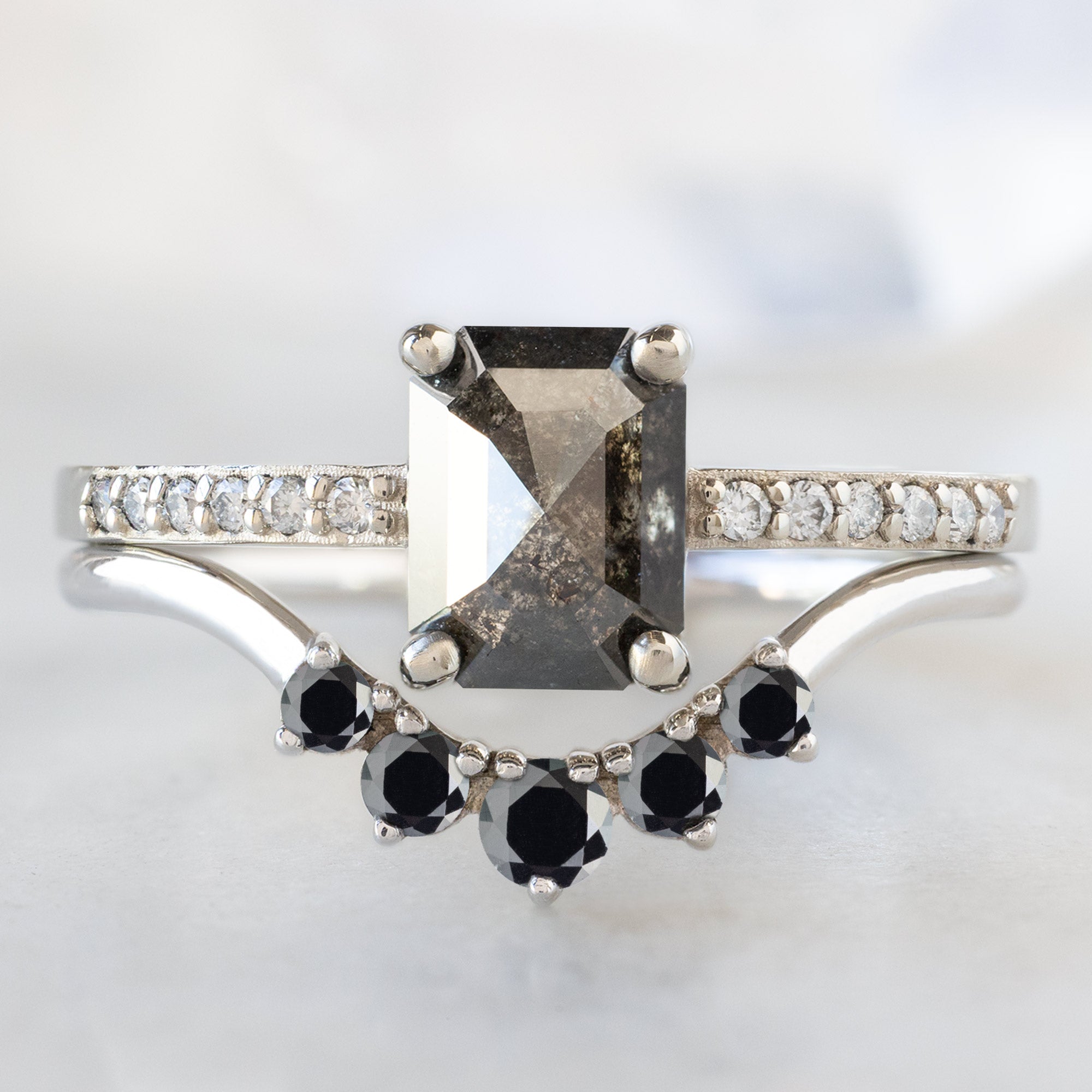 The Willow Ring with a 1.05ct Emerald Cut Black Diamond in 14K White Gold Stacked with the Round Black Diamond Sunburst Stacking Band