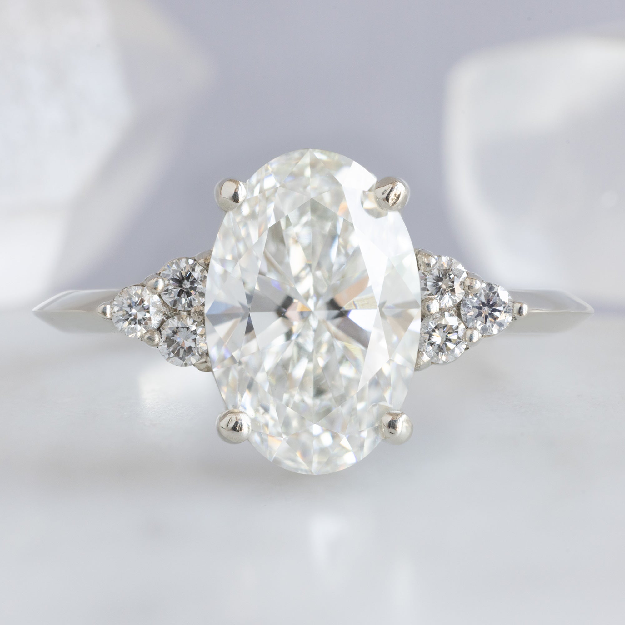The Ivy Ring with a 1.88ct Oval Lab Grown White Diamond in 14K White Gold on light grey background