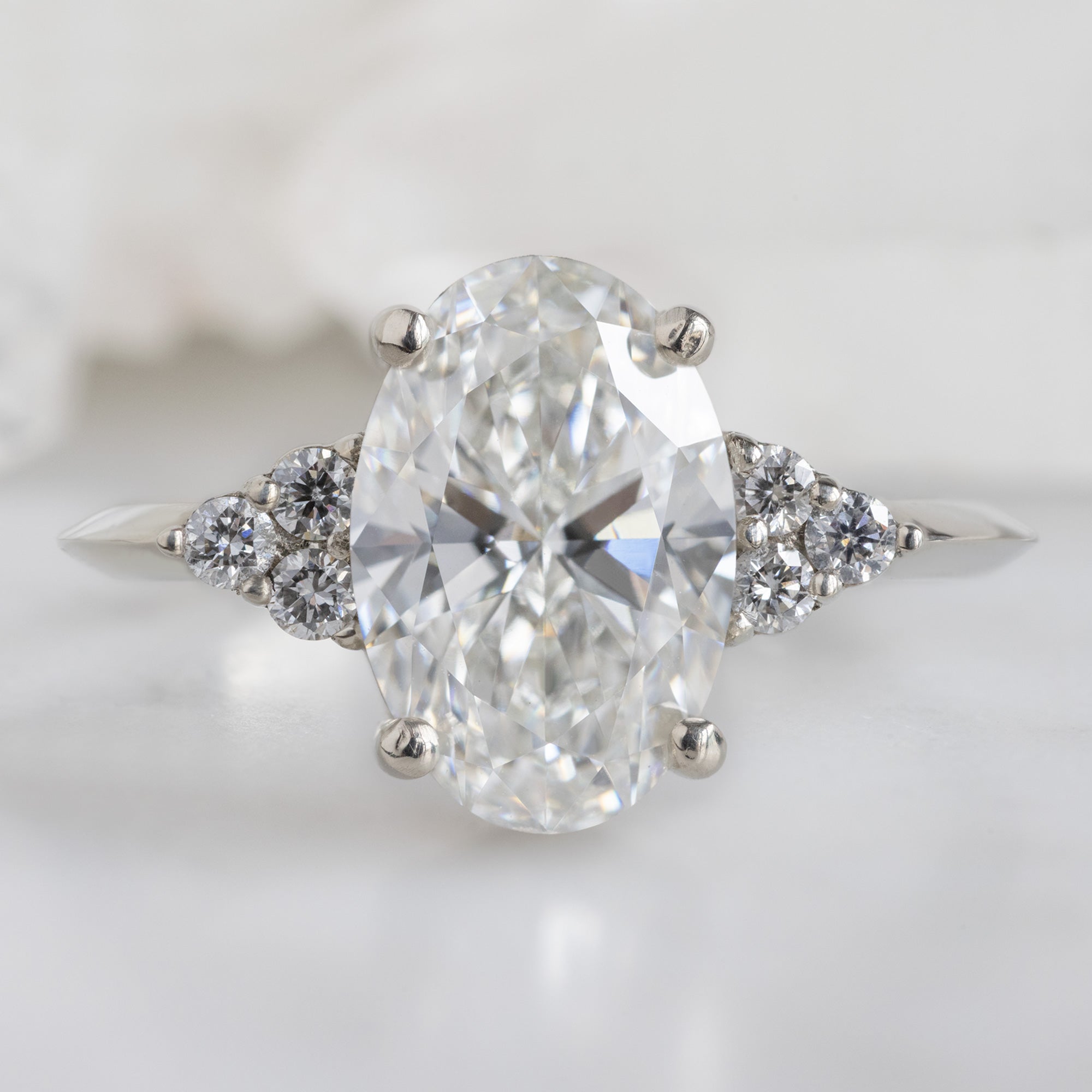 The Ivy Ring with a 1.88ct Oval Lab Grown White Diamond in 14K White Gold on White Marble