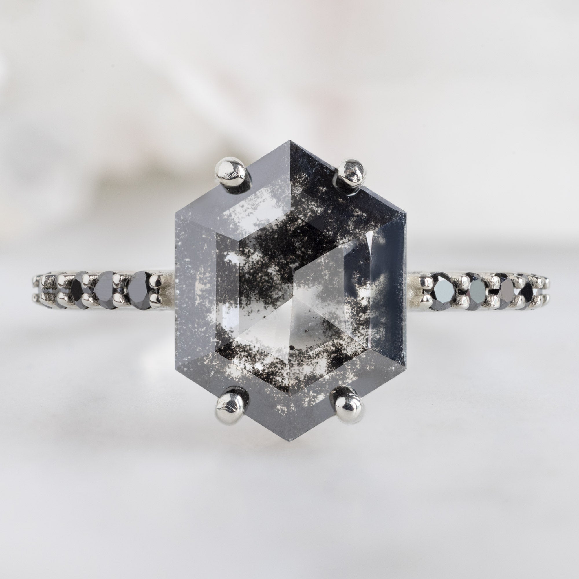 The Luxe Willow Ring with a 2.17ct Lab Grown Salt and Pepper Hexagon Diamond in 14K White Gold on White Marble Surface