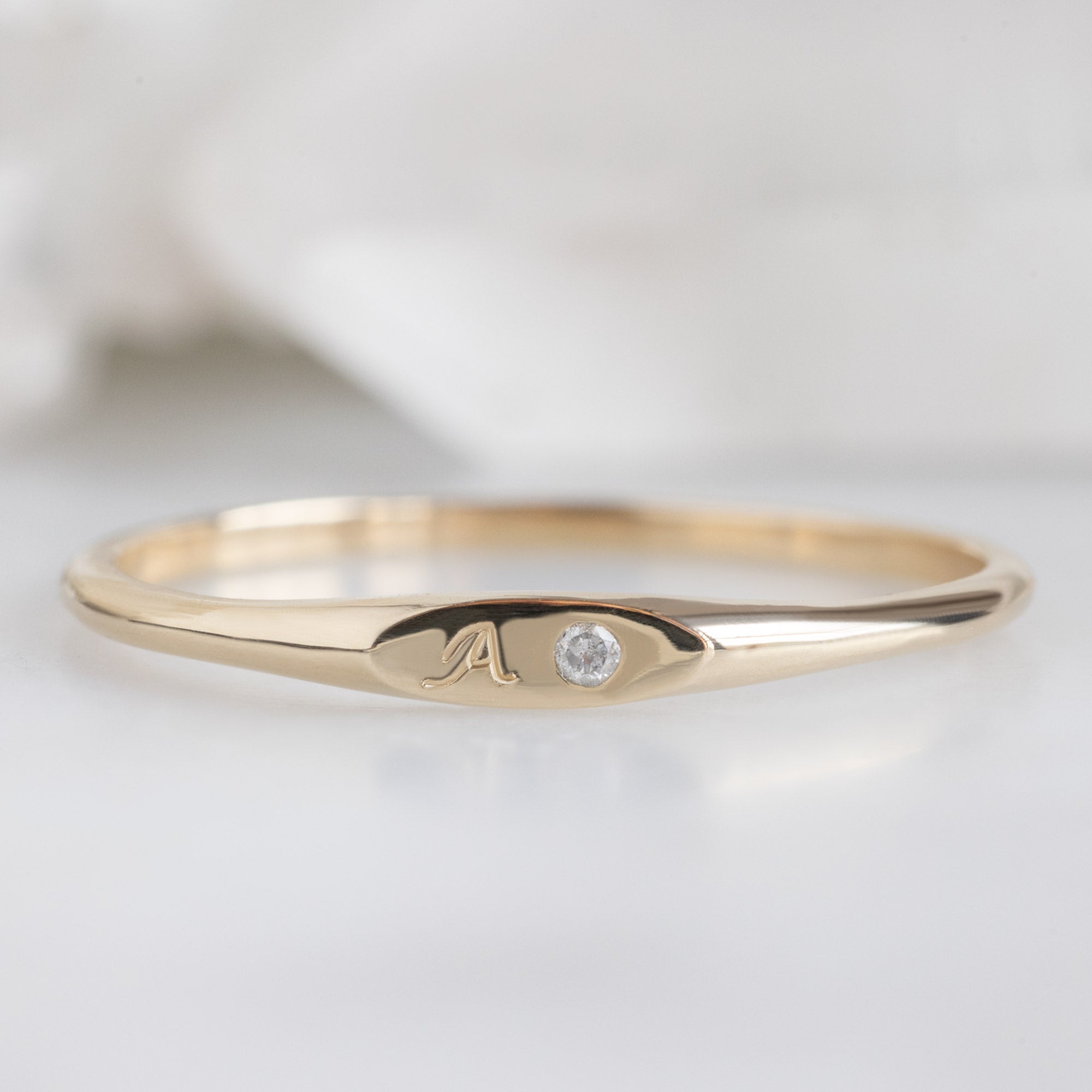 The Teensy White Diamond Signet Ring in 10K Yellow Gold on White Marble