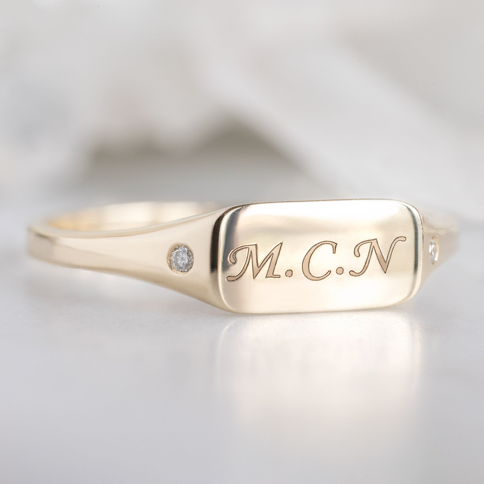 Side View of The Monogram Signet Ring in 10K Yellow Gold on White Marble