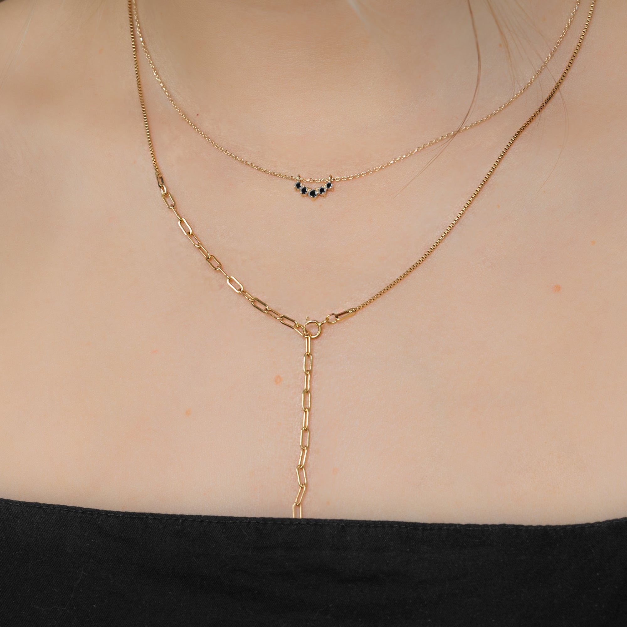 Custom Black Diamond Sunburst Necklace | 10K Yellow Gold. Displayed on model's neck paired with another chain.