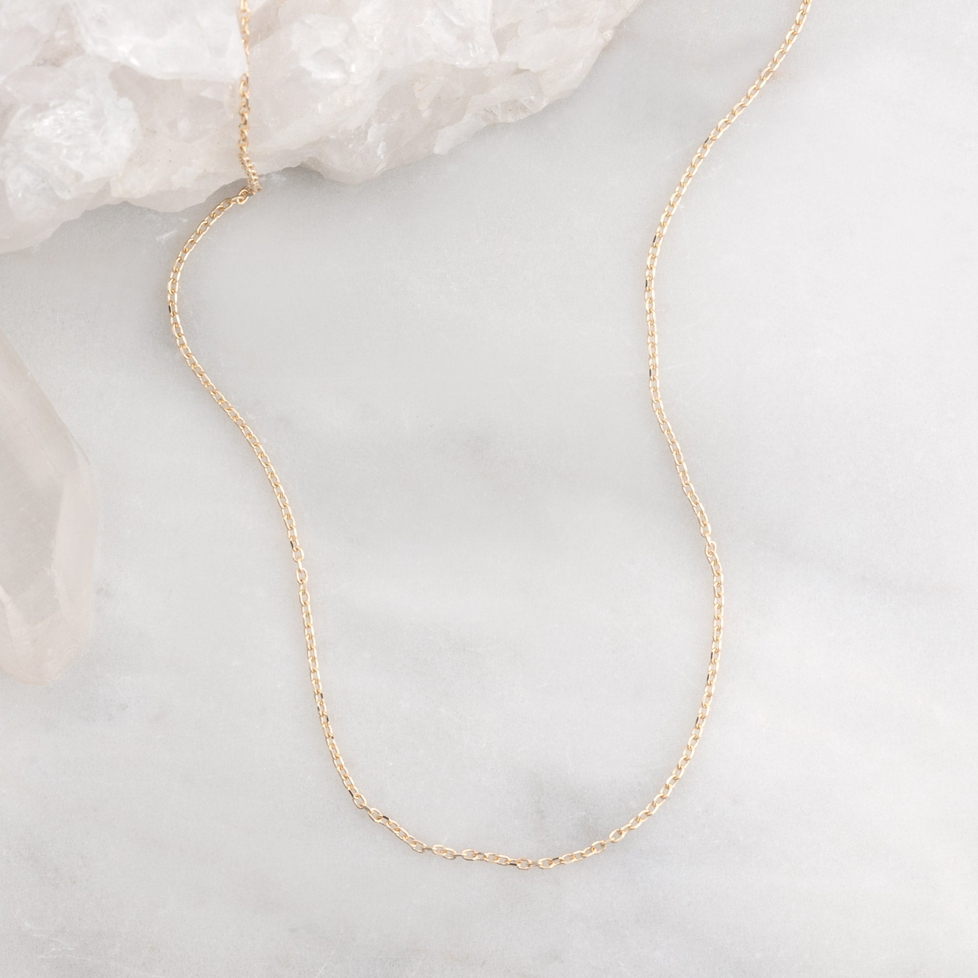The Diamond-Cut Cable Chain Charm Necklace in 10K Yellow Gold on White Marble